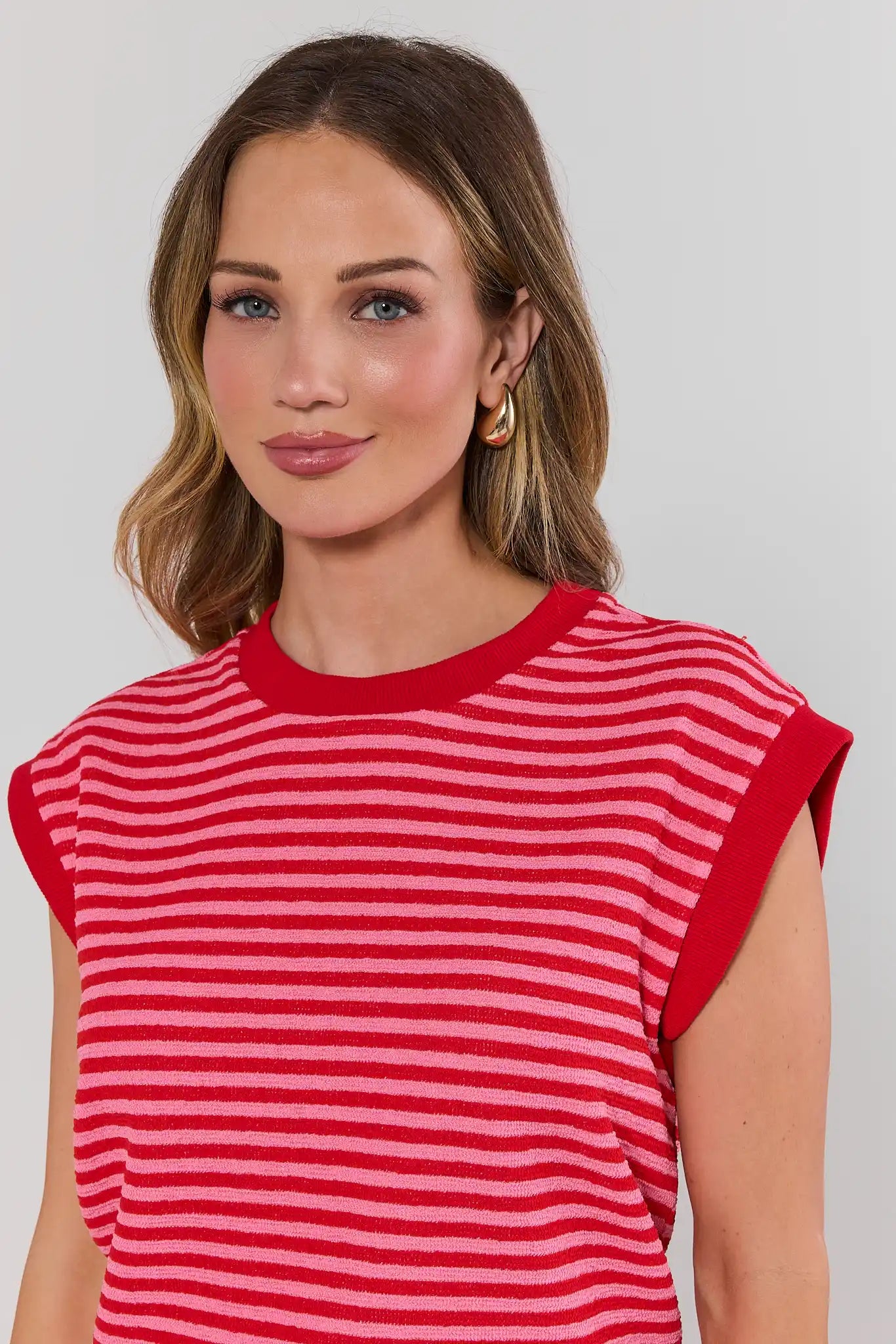 Woman wearing a red and white striped shirt against a plain background close up
