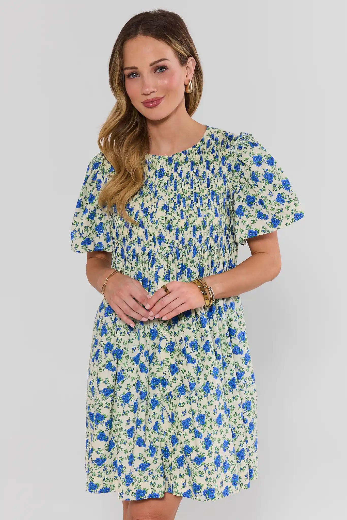 Woman wearing a floral dress against a plain background