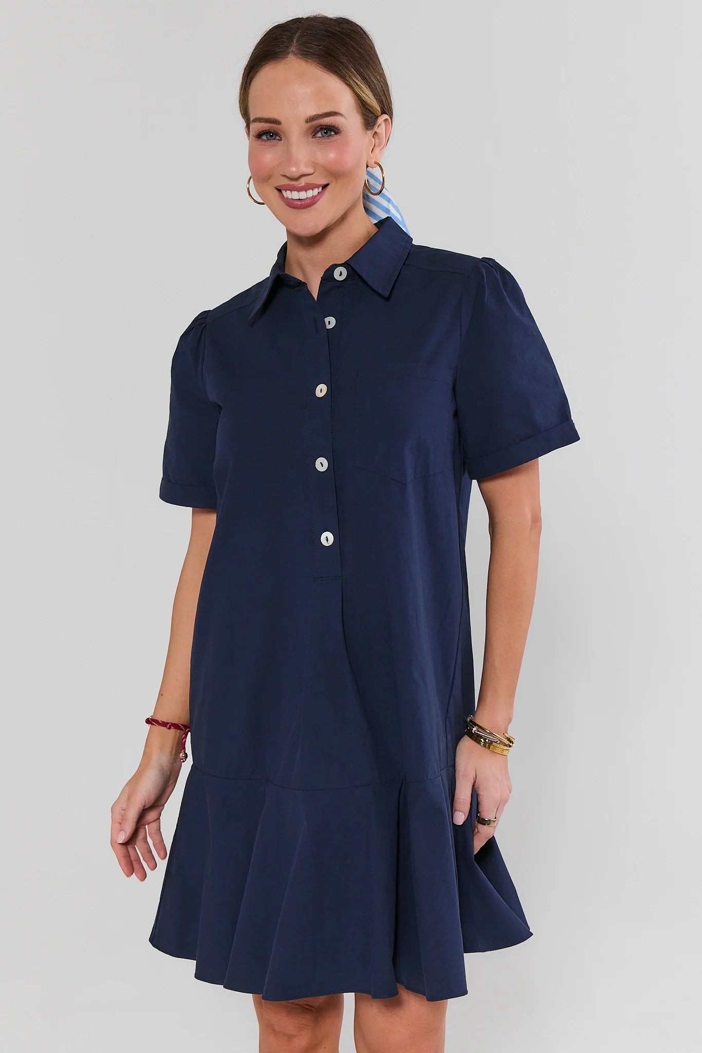 Woman wearing a navy blue dress with a white background