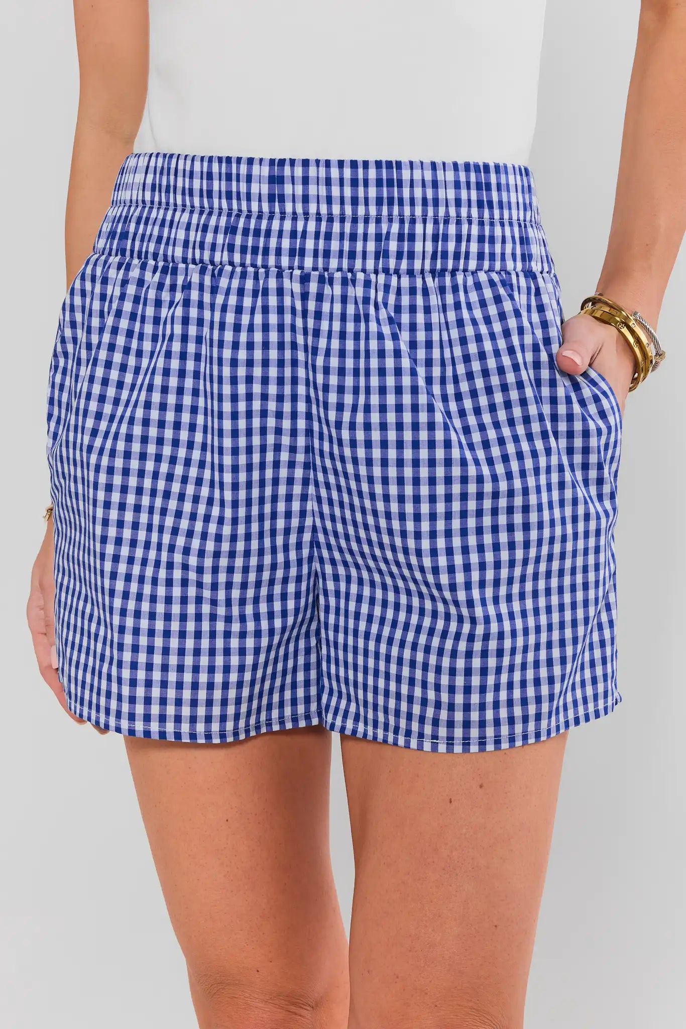 Blue and white checkered shorts worn by a person on a plain background close