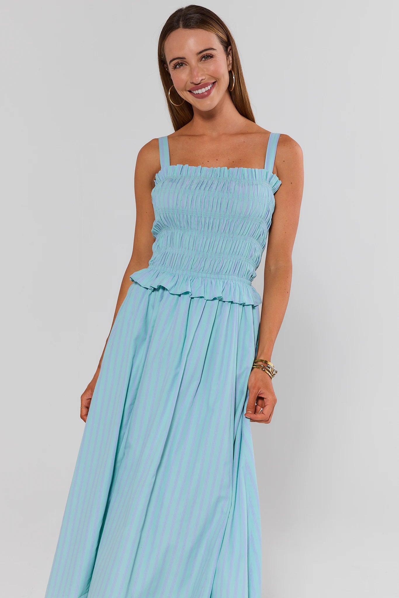 Woman wearing a light blue dress against a plain background