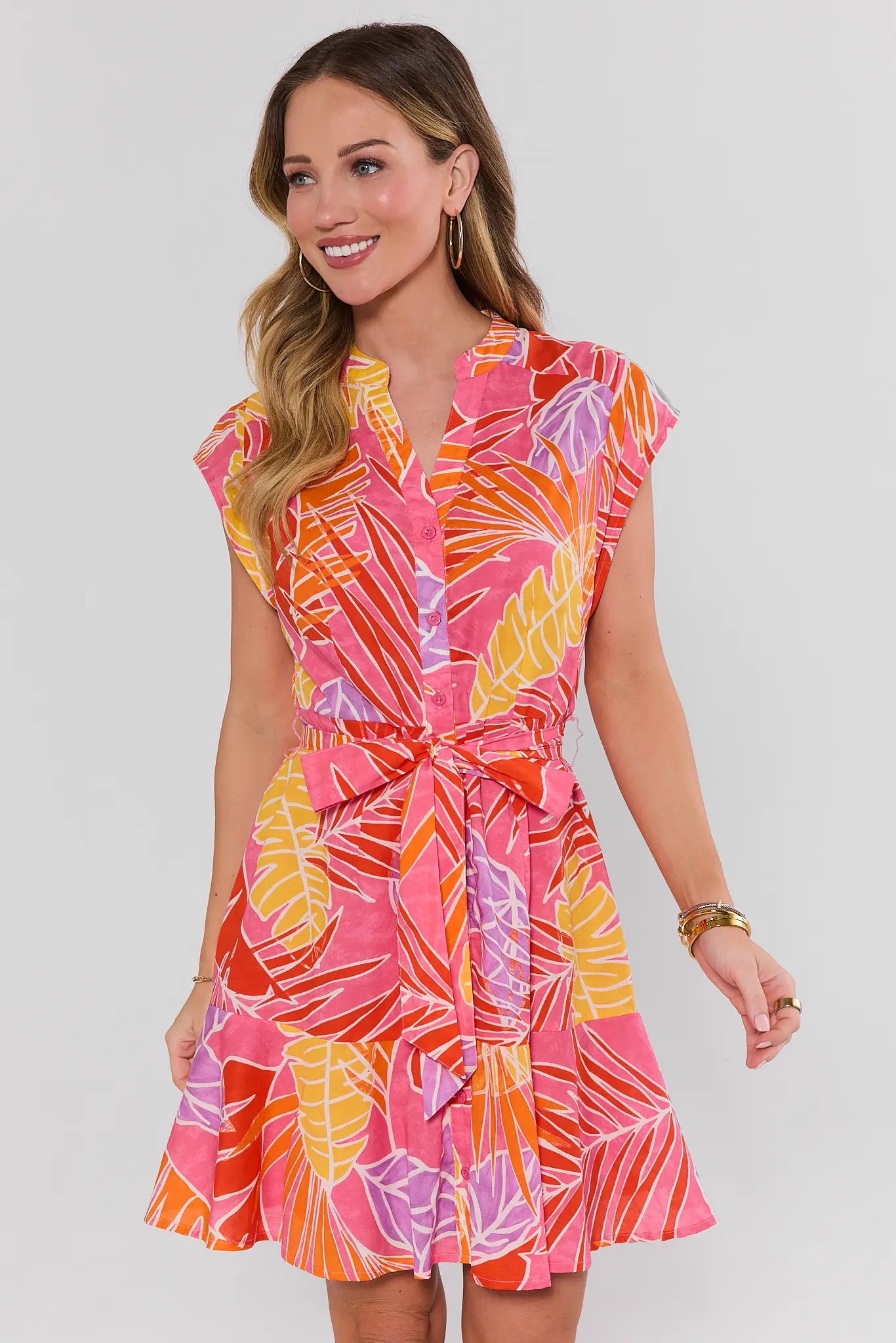 Woman wearing a colorful dress with a white background standing