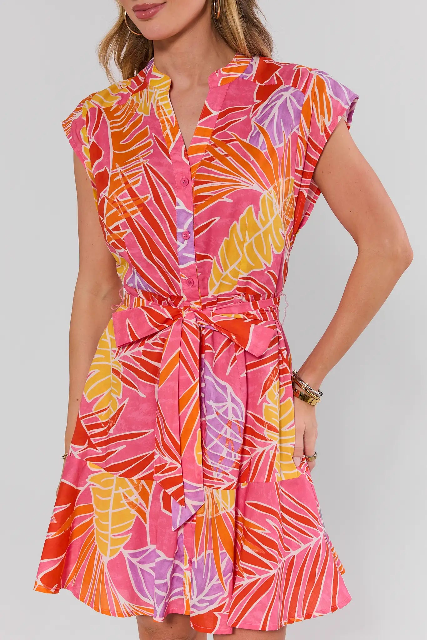 Woman wearing a colorful dress with a leaf pattern on a white background close up