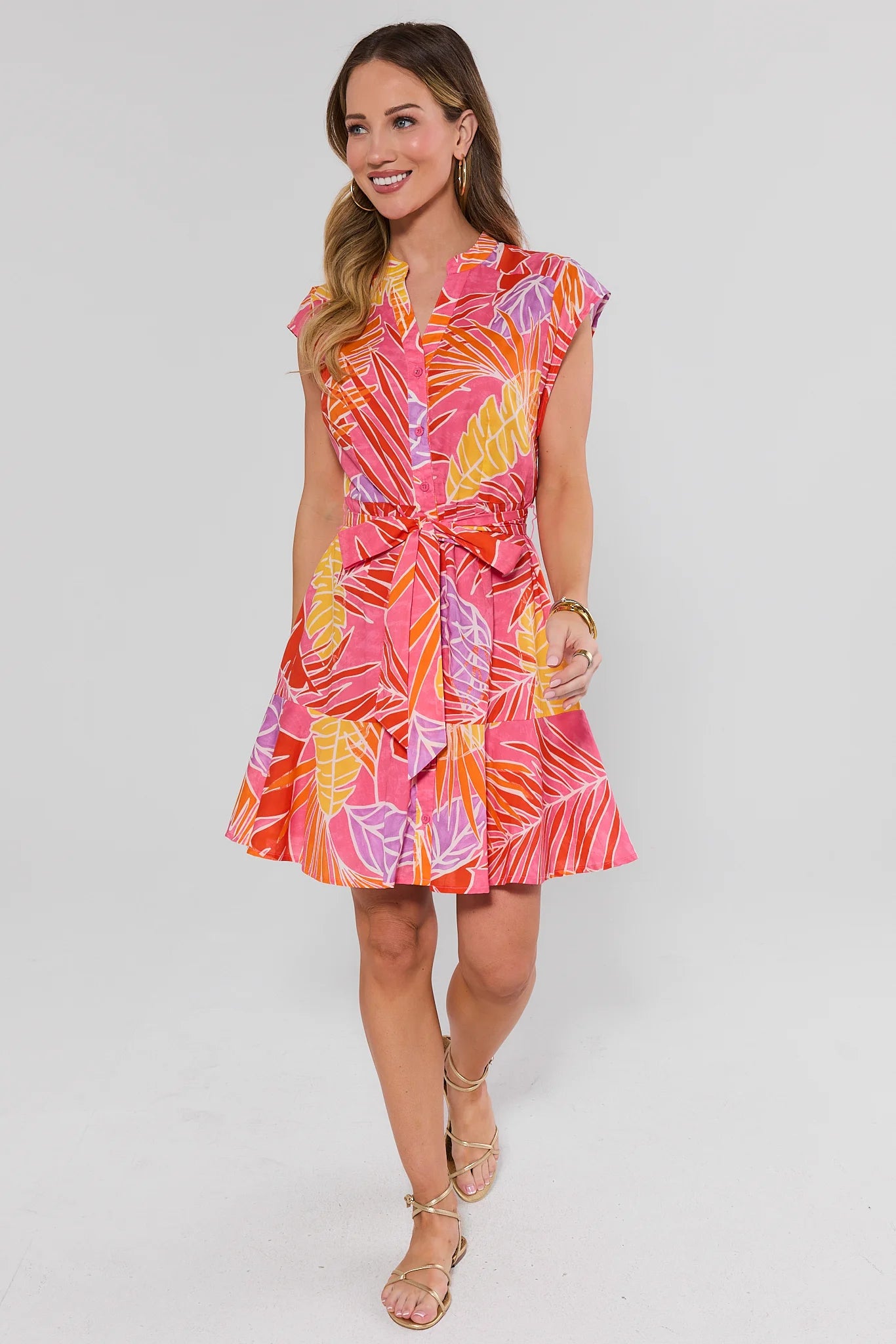 Woman wearing a colorful dress with a white background standing
