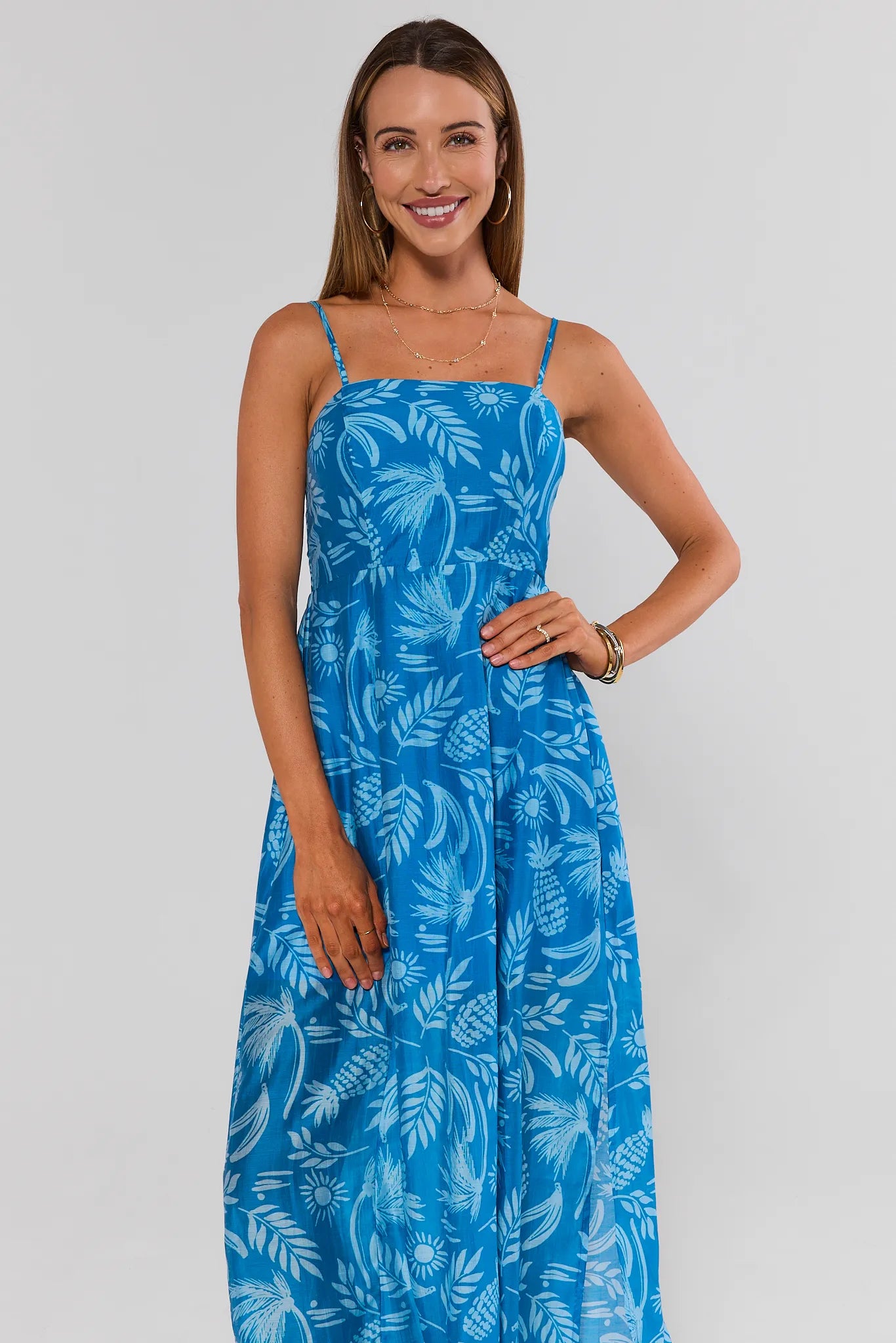 Woman wearing a blue floral dress against a white background