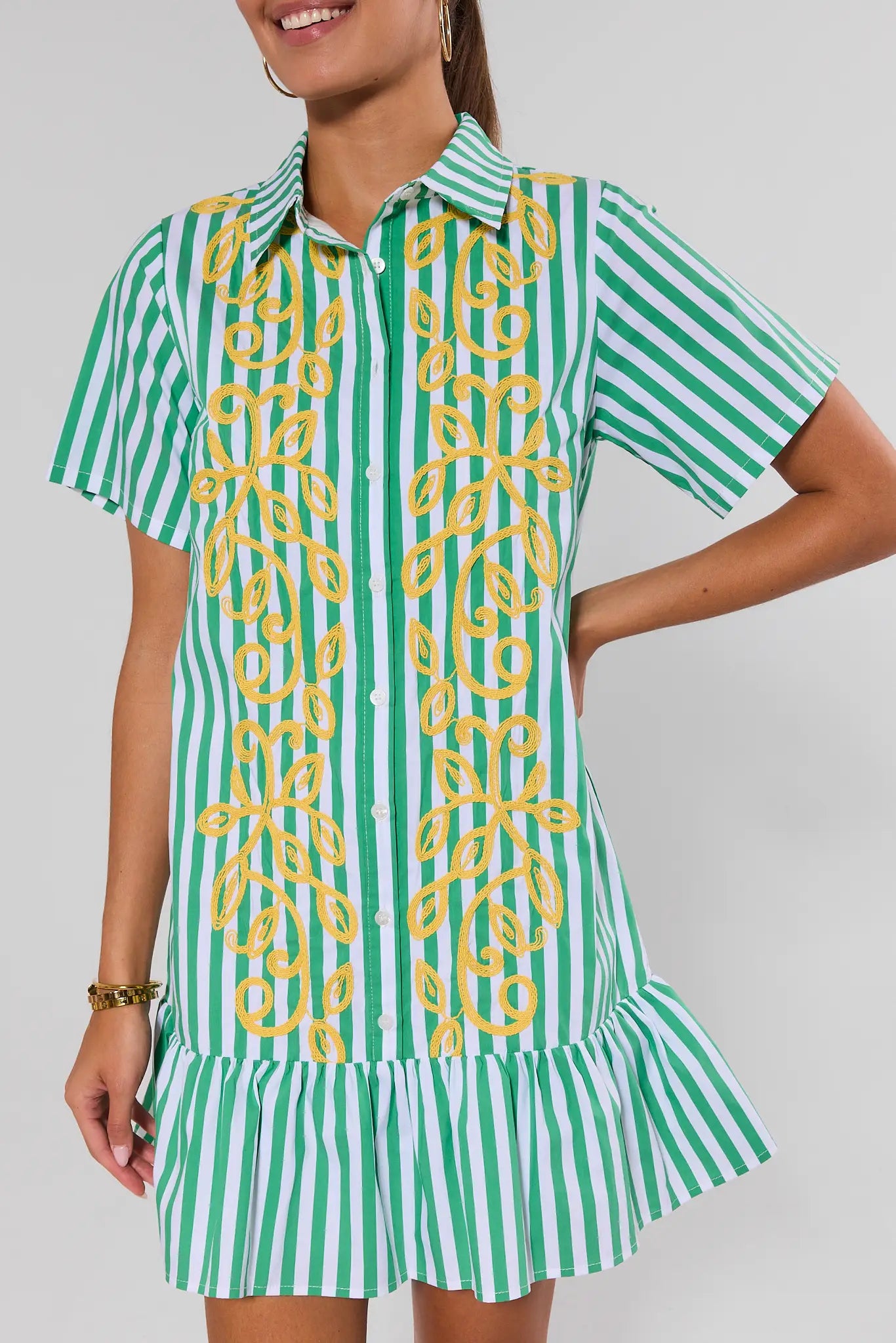 Green and white striped dress with yellow pattern on a plain background up