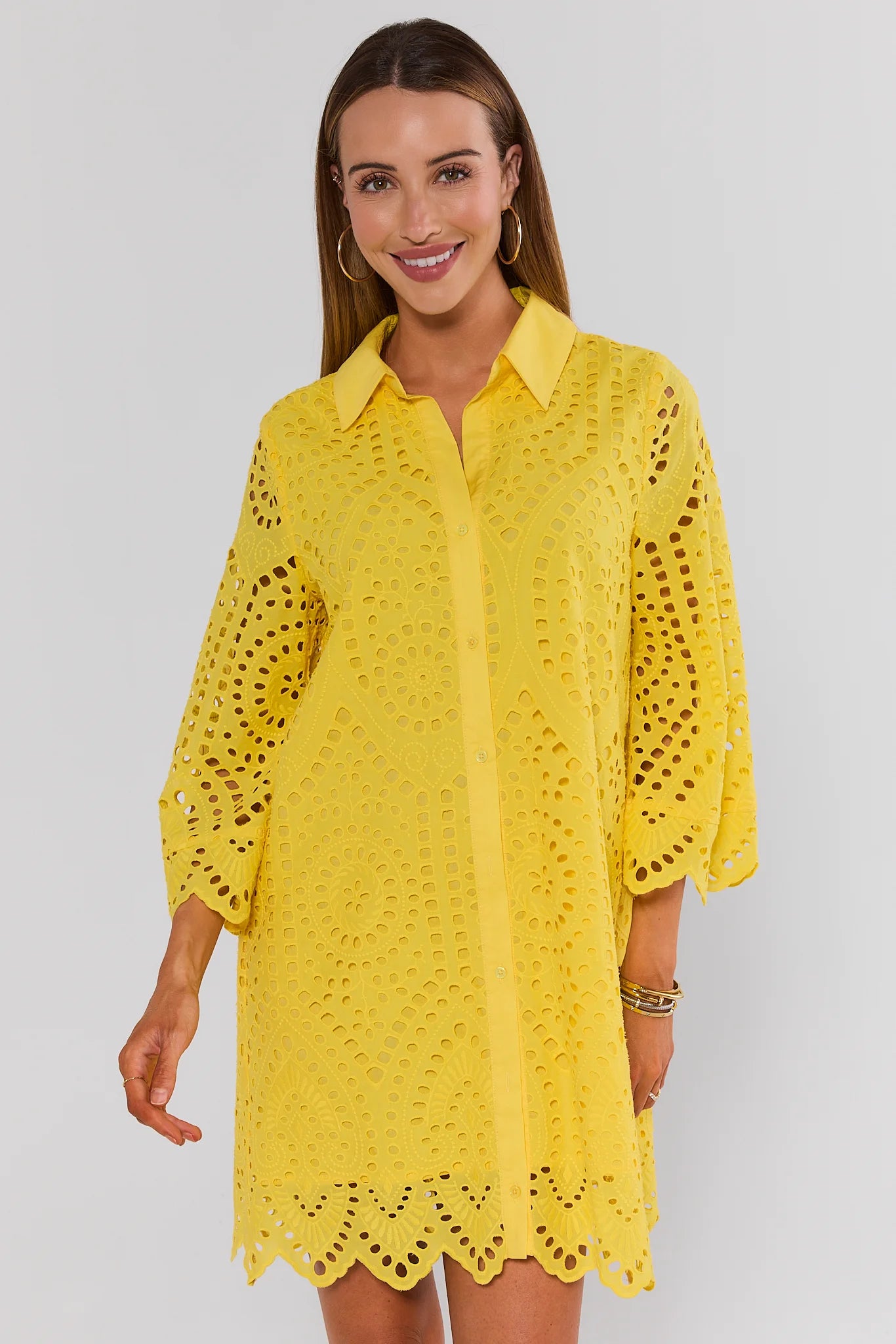 Woman wearing a yellow lace dress on a plain background