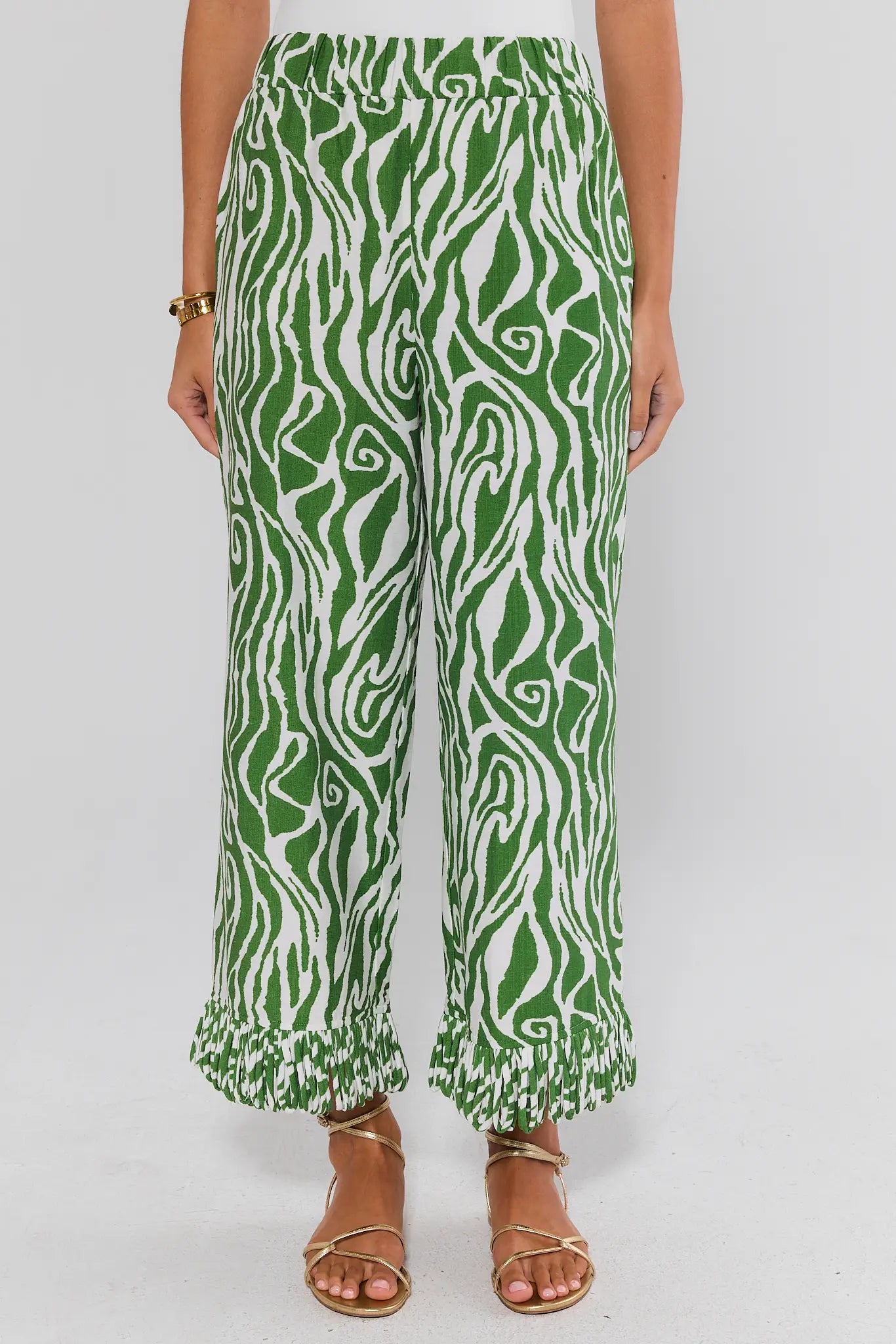 Green and white patterned pants worn by a person on a white background