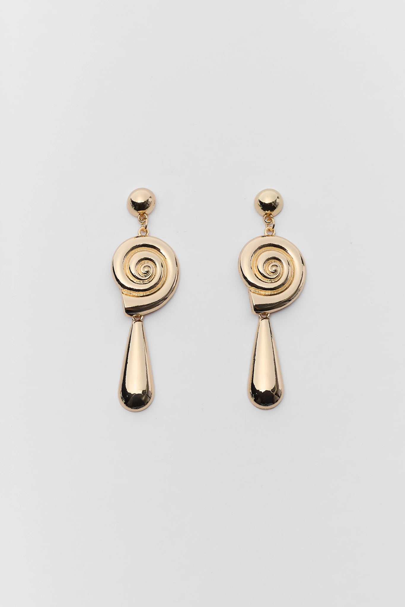 Pair of gold spiral earrings on a gray background