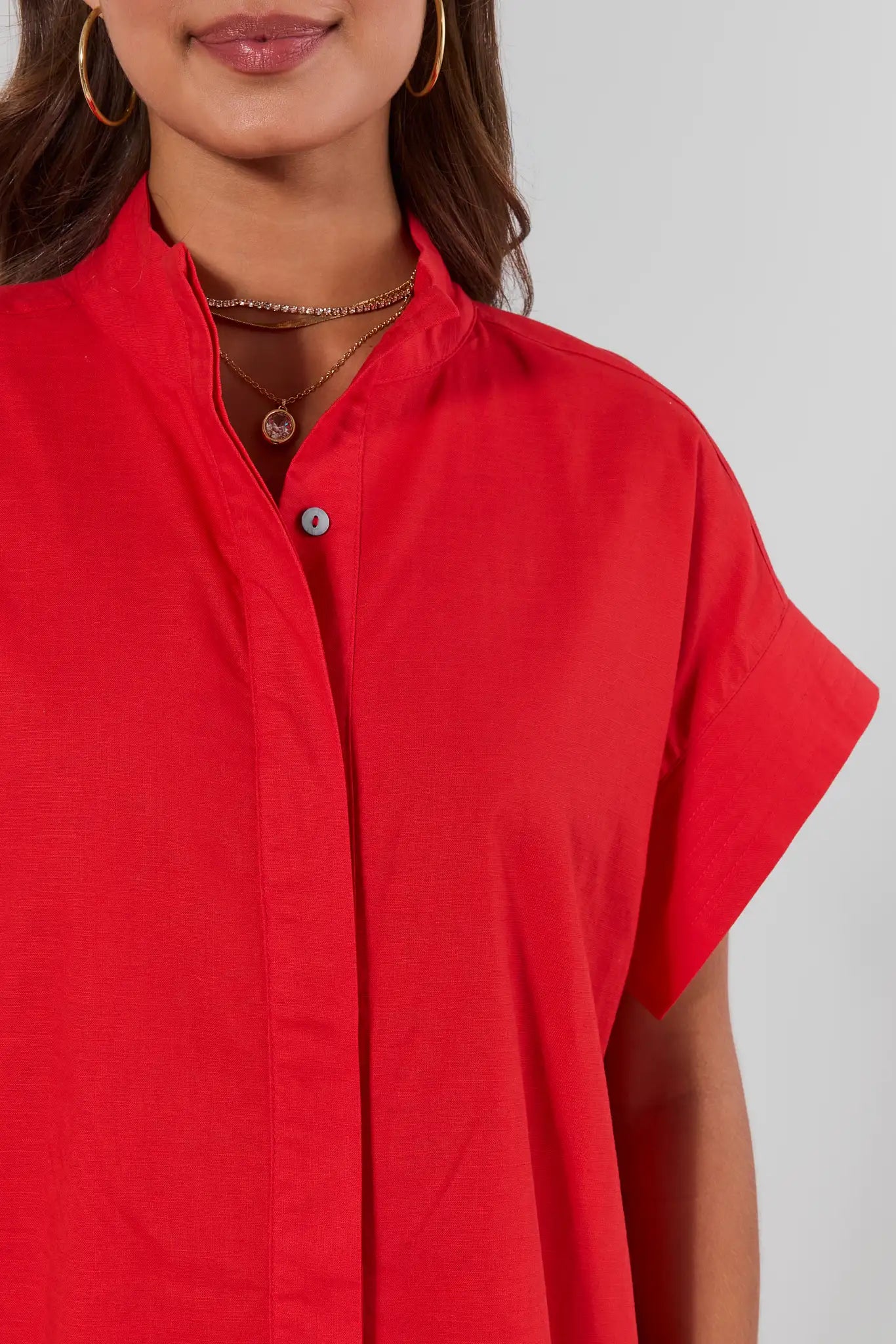 Red shirt worn by a person on a plain background close up