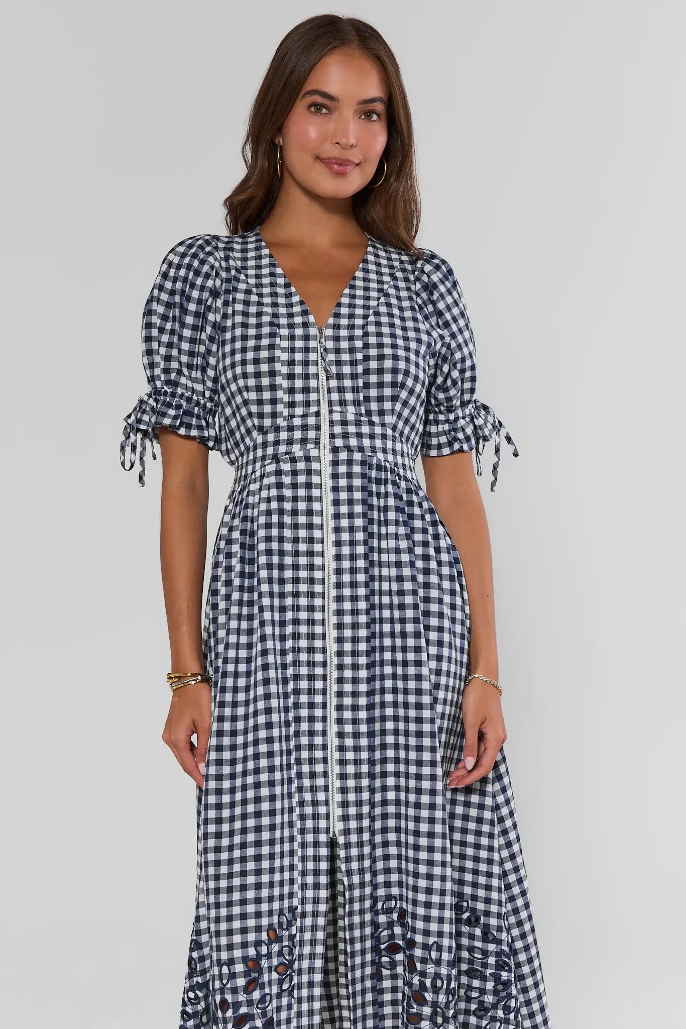 Woman wearing a black and white checkered dress on a gray background standing