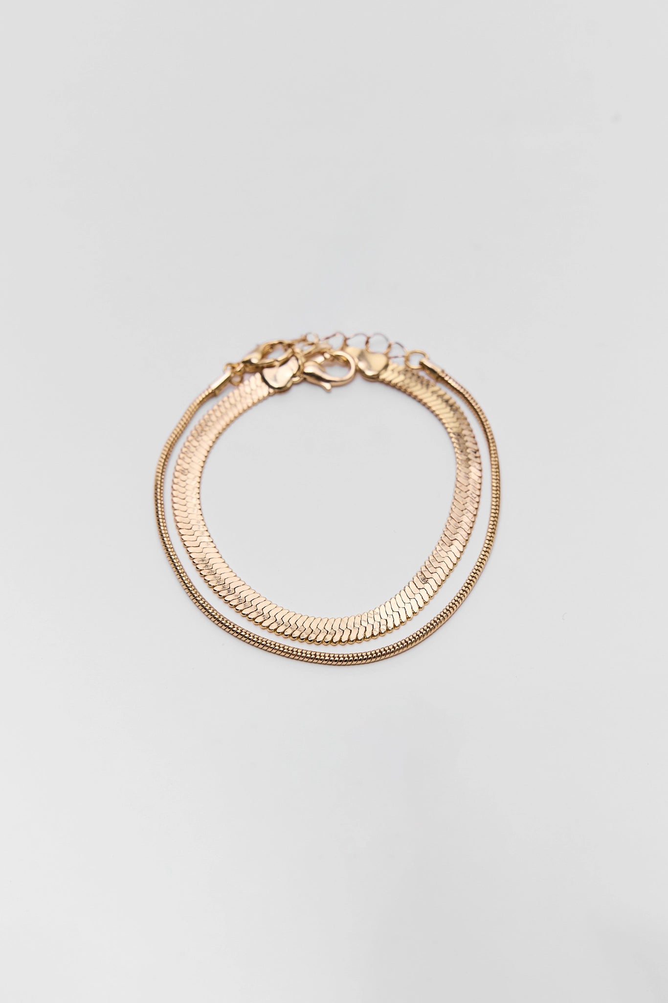 Gold bracelet on a light gray background