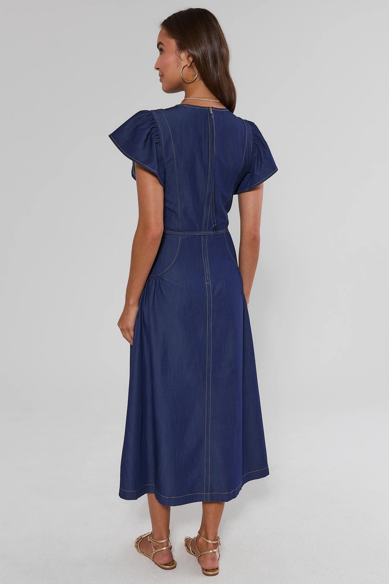 Woman wearing a blue dress on a white background standing