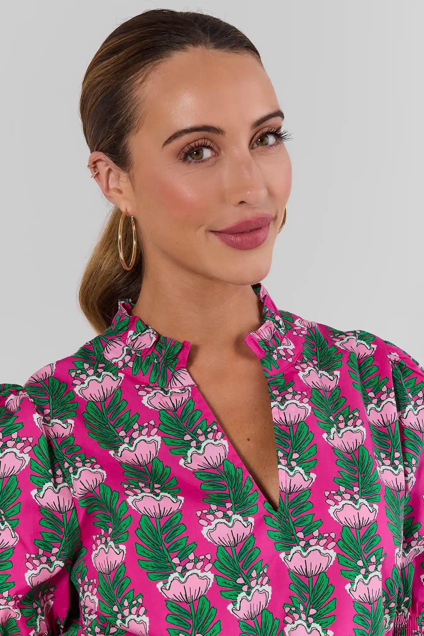 Close up woman wearing amanda pink floral green top on white background