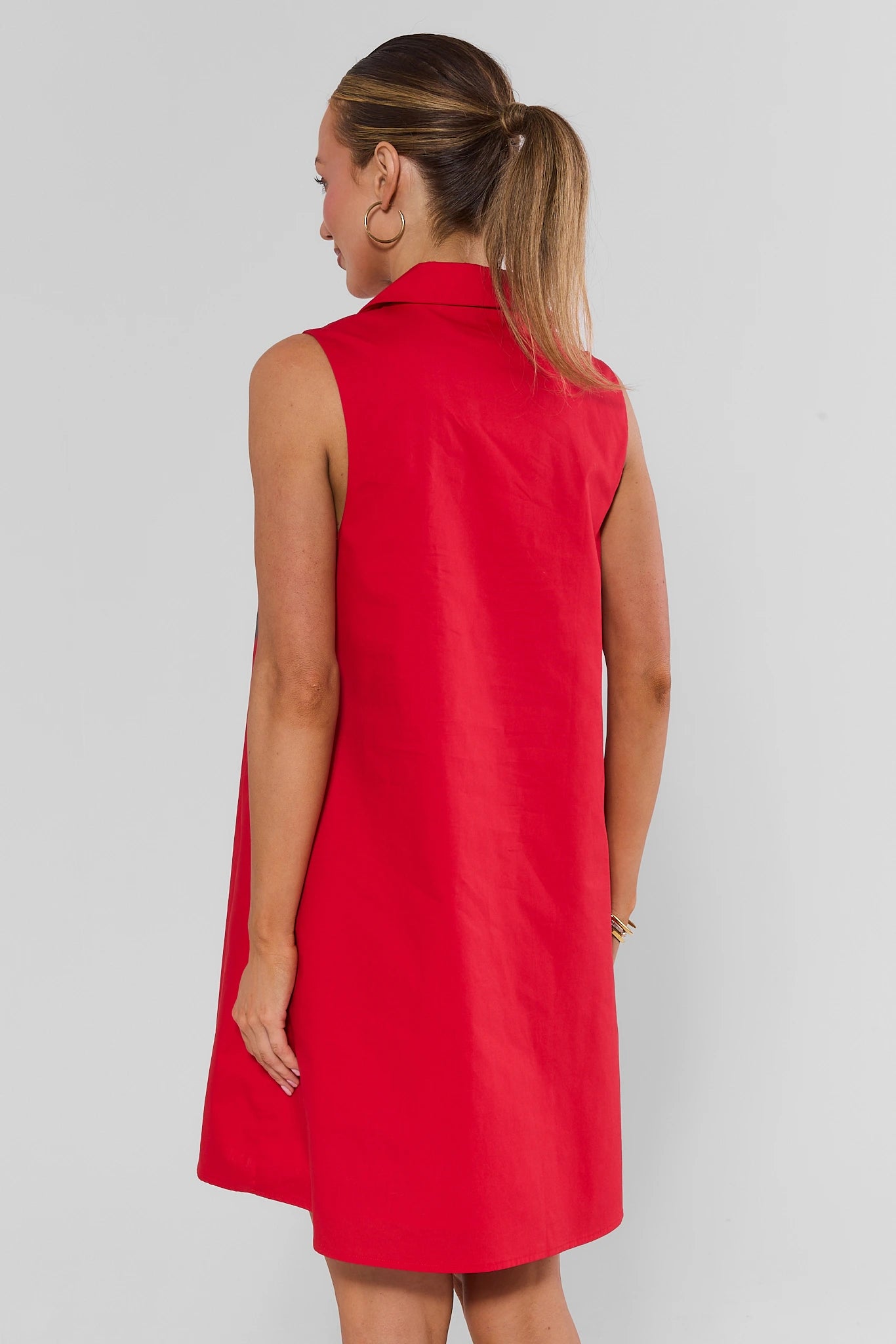 Woman standing backwards wearing red ellen short dress on white background