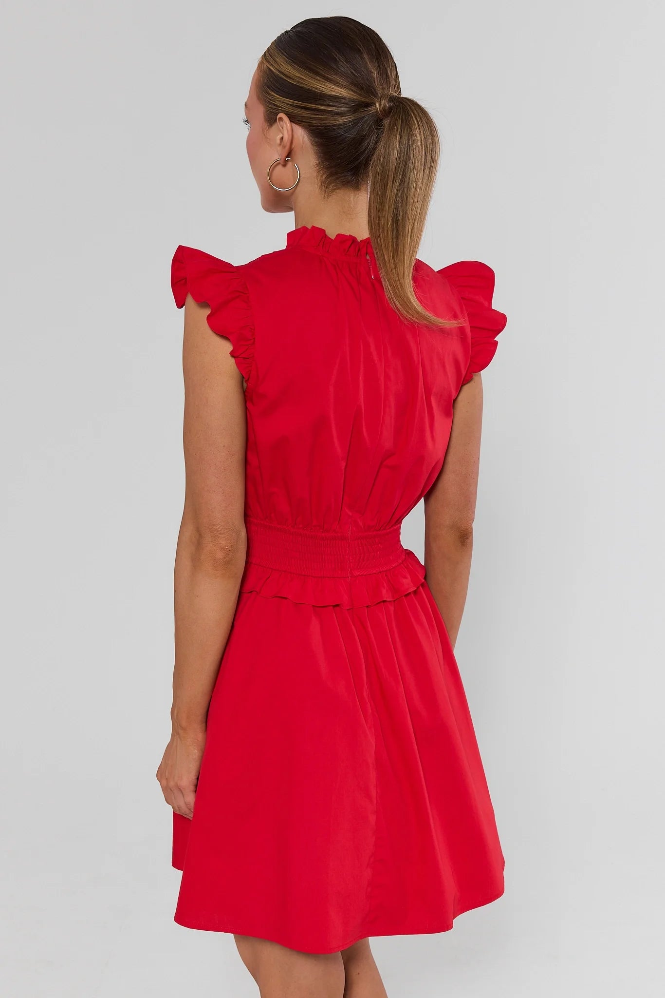 Woman standing wearing Makayla Red Flutter Sleeve Short Dress on a white background