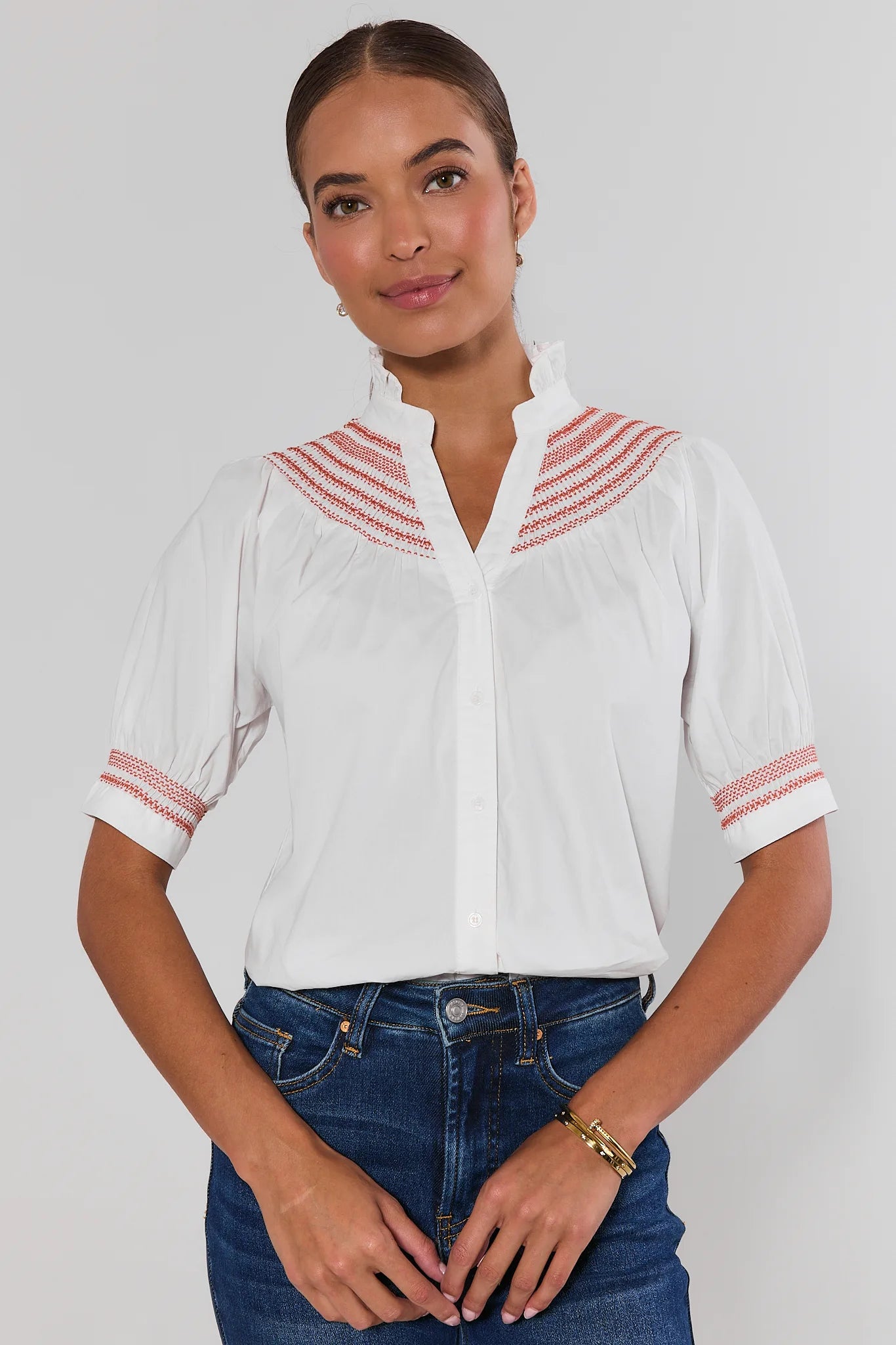 Woman wearing Yvonne White and Orange Embroidered Top on a white background