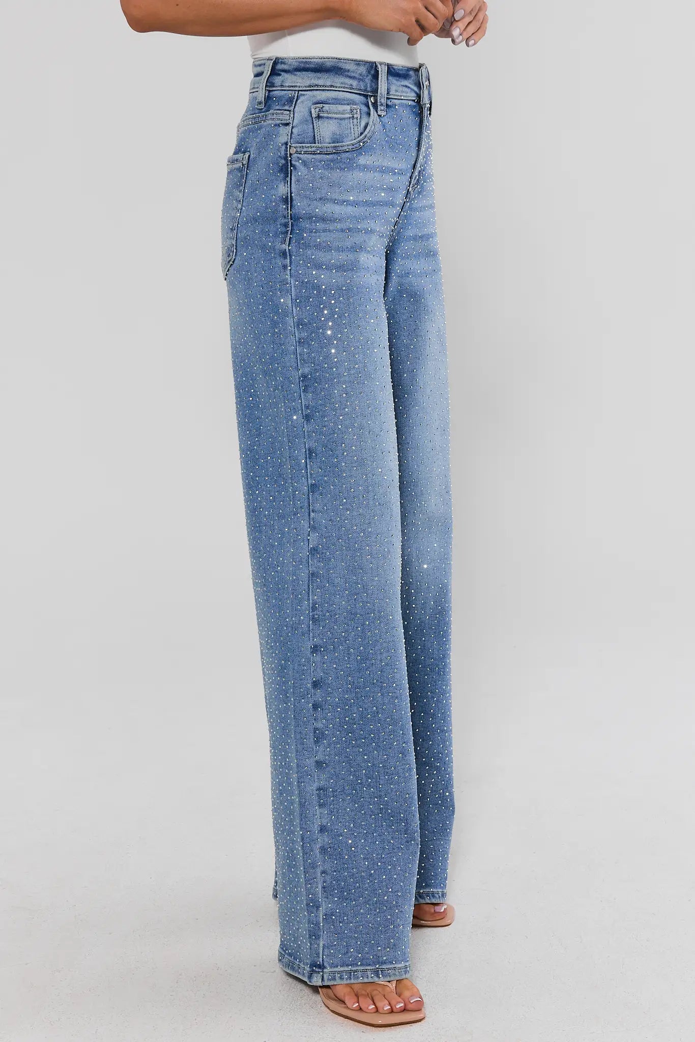 Woman wearing Carrie Rhinestone Wide Leg Jeans on a white background standing side