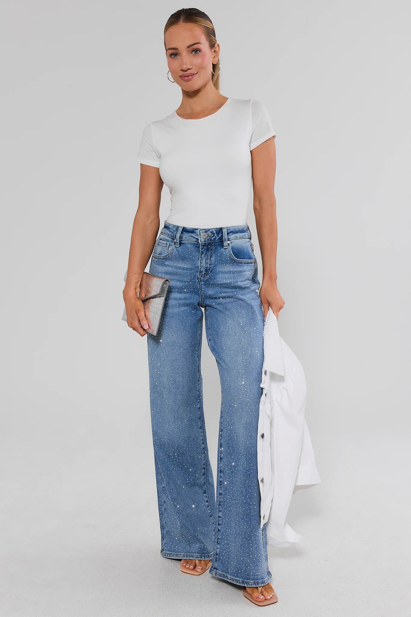 Woman wearing a white shirt and Carrie Rhinestone Wide Leg Jeans on a white background