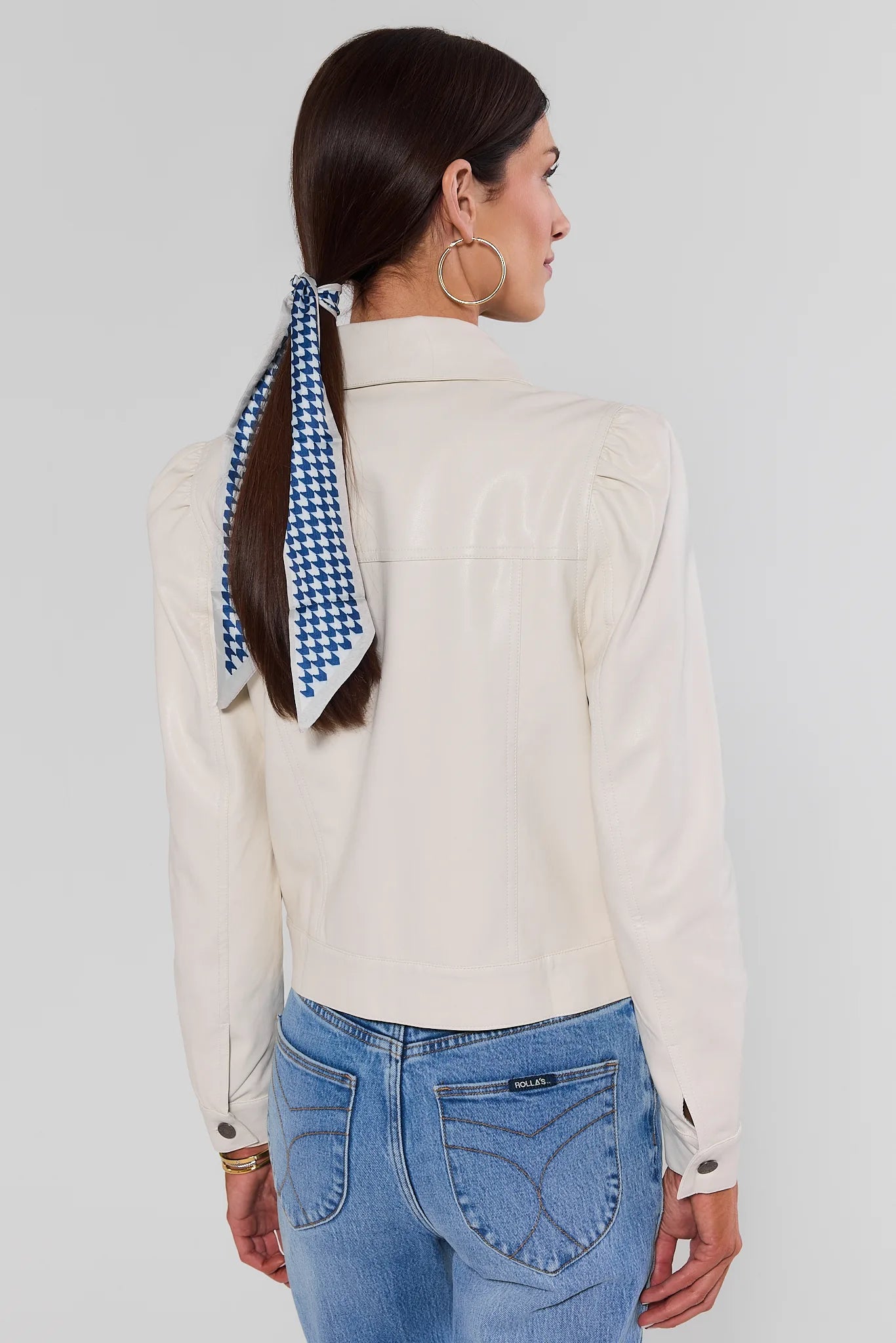 Woman wearing Roxanna Cream Faux Leather Jacket with jeans on a white background standing backwards