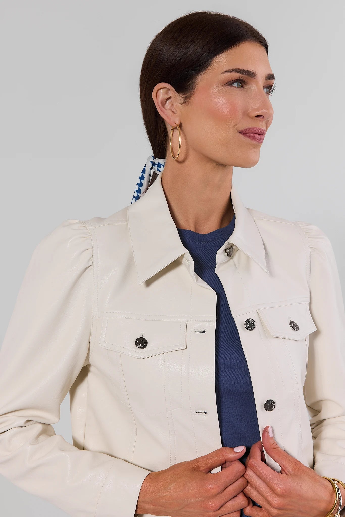 close up Woman wearing Roxanna Cream Faux Leather Jacket with jeans on a white background