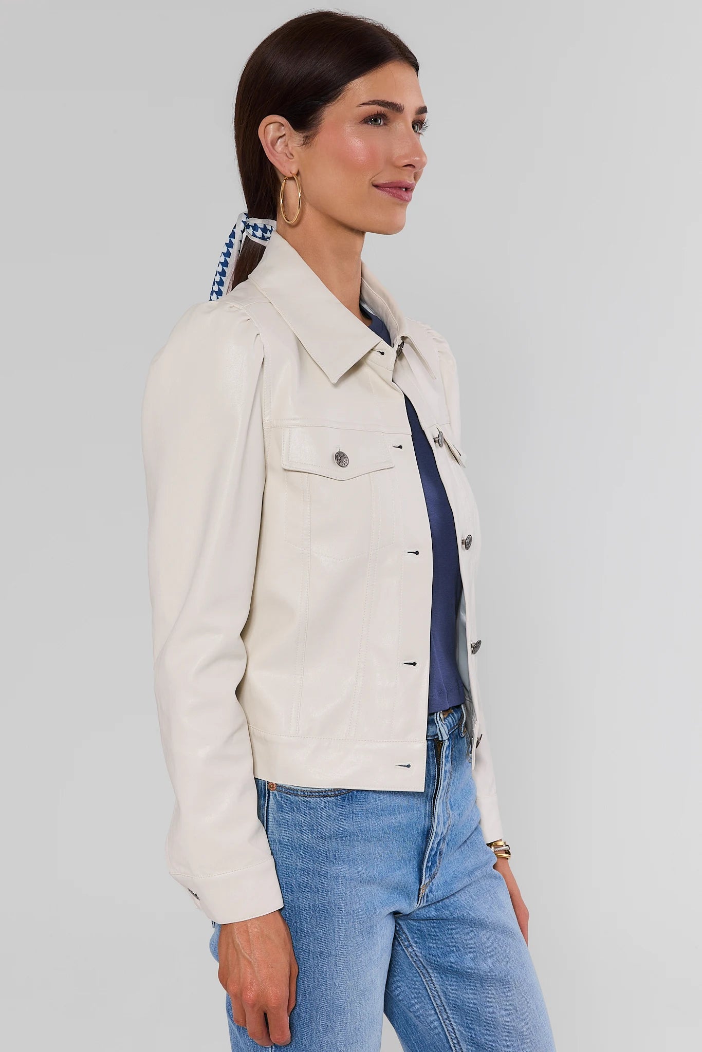 Woman wearing Roxanna Cream Faux Leather Jacket with jeans on a white background side