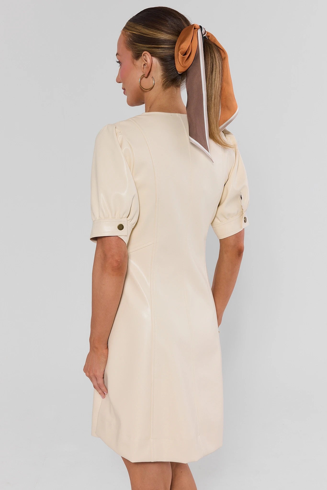 Woman turned wearing Ivory Faux Leather Short Dress on a white background
