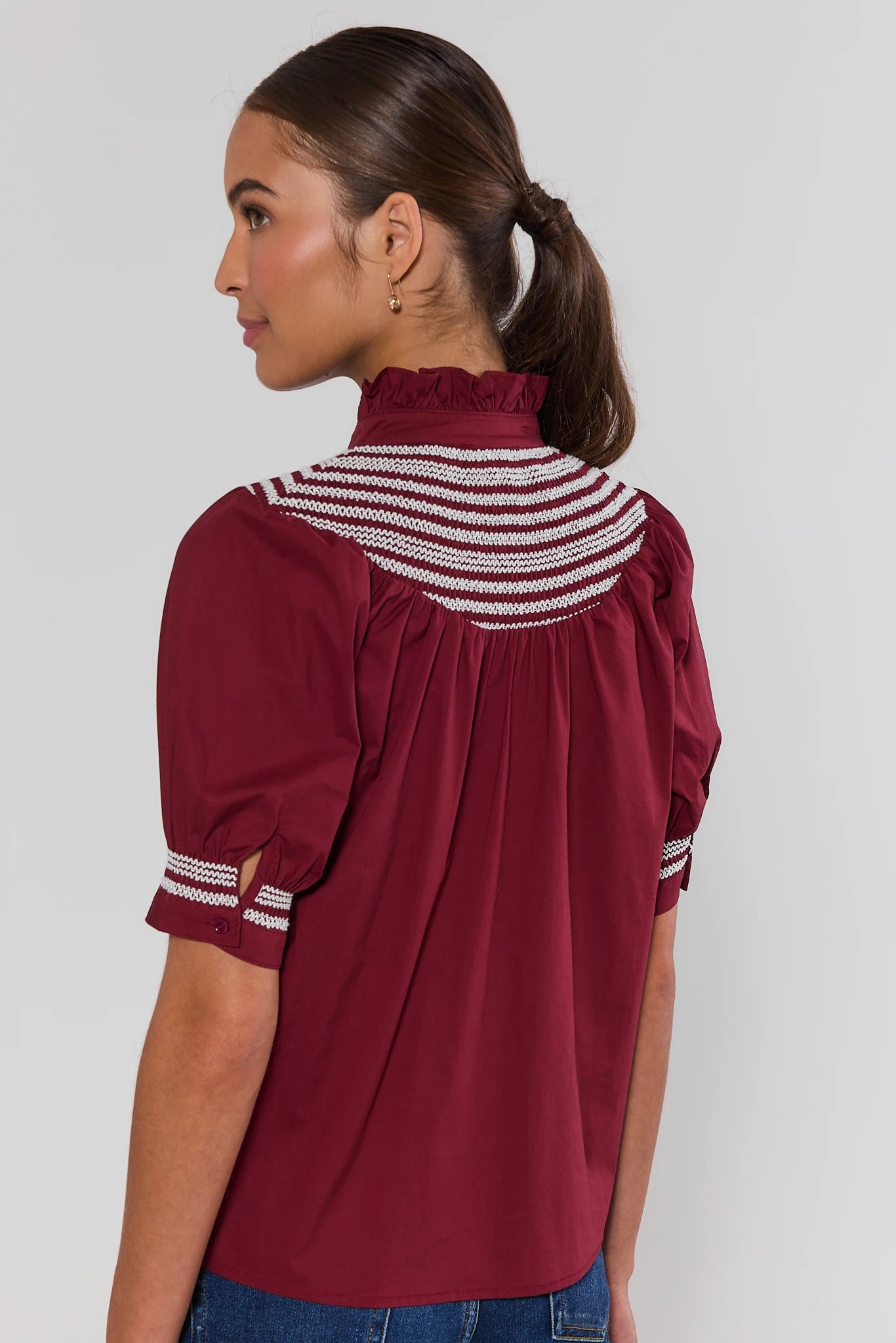 Woman wearing Yvonne Burgundy and White Embroidered Top on a white background standing