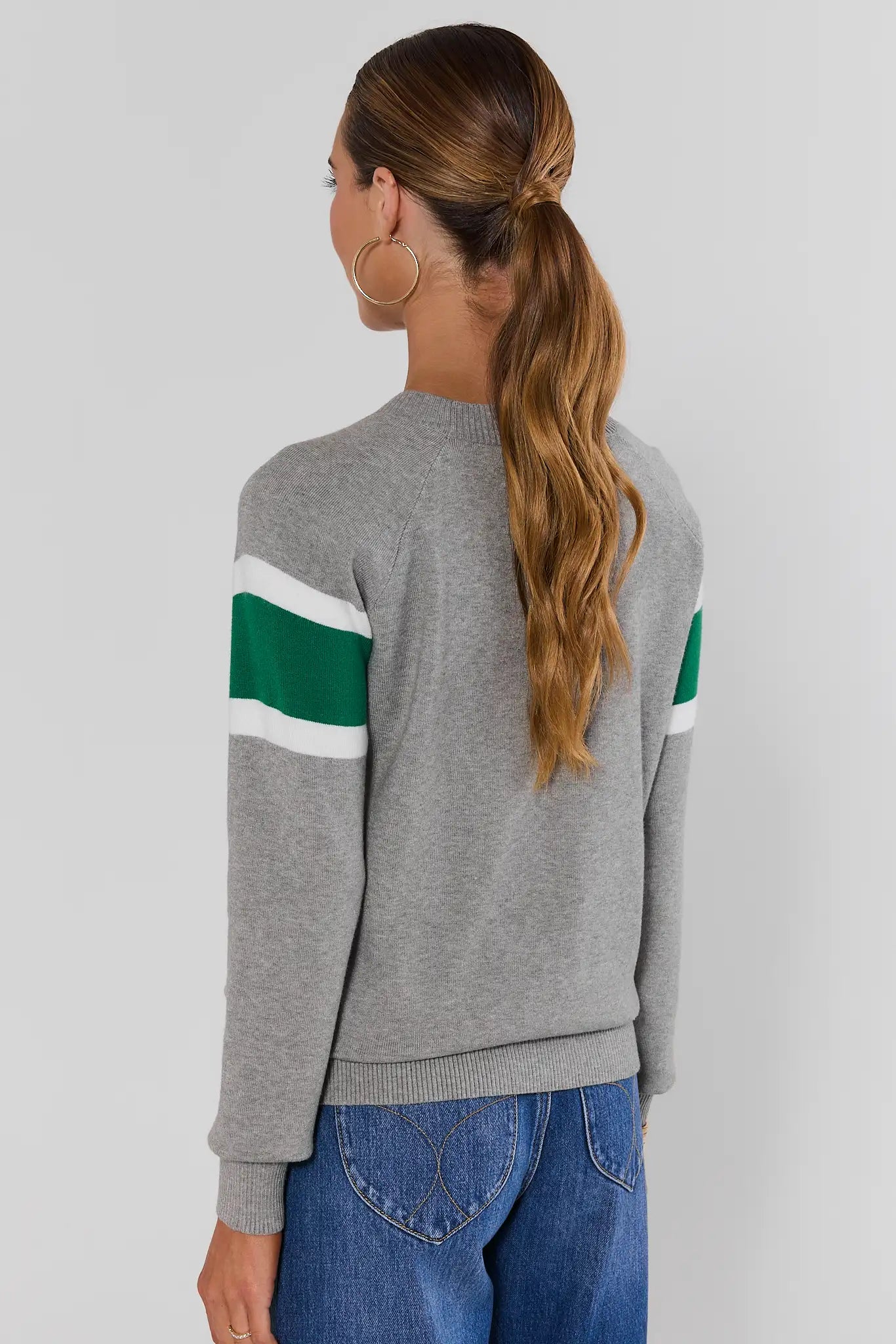 Woman wearing Dylan Green Stripe Sweater on a white background turned