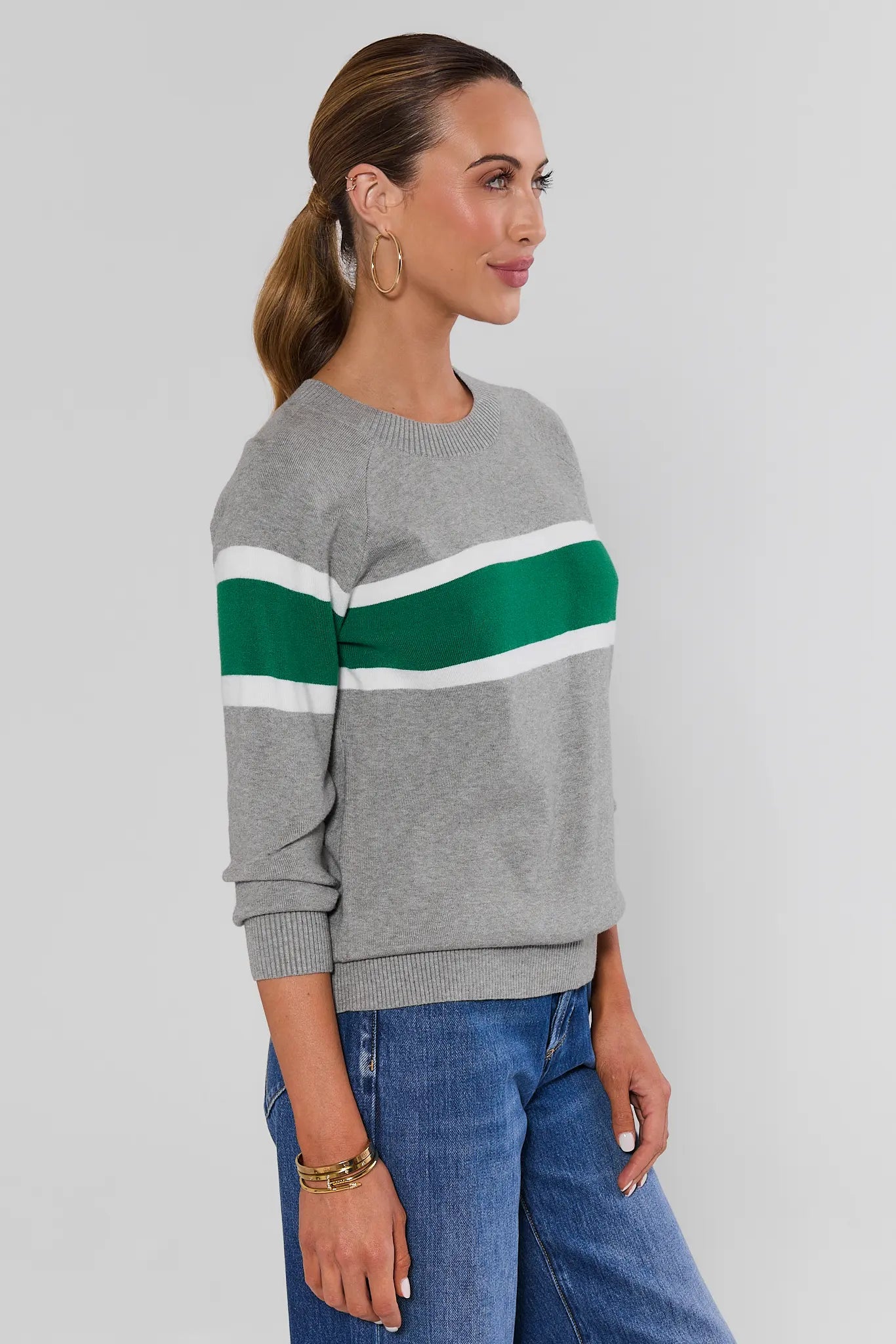 Woman wearing Dylan Green Stripe Sweater on a white background side