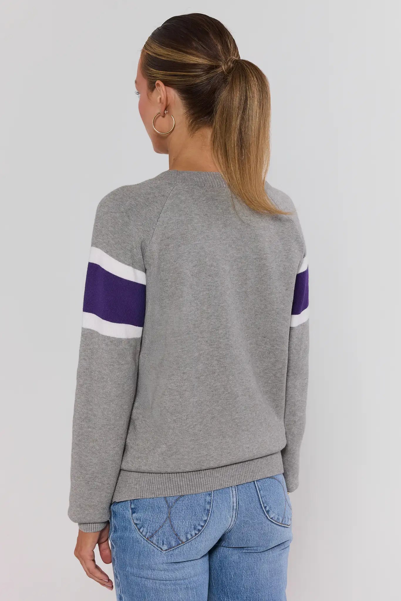 Woman wearing Dylan Purple Stripe Sweater on a white background turned