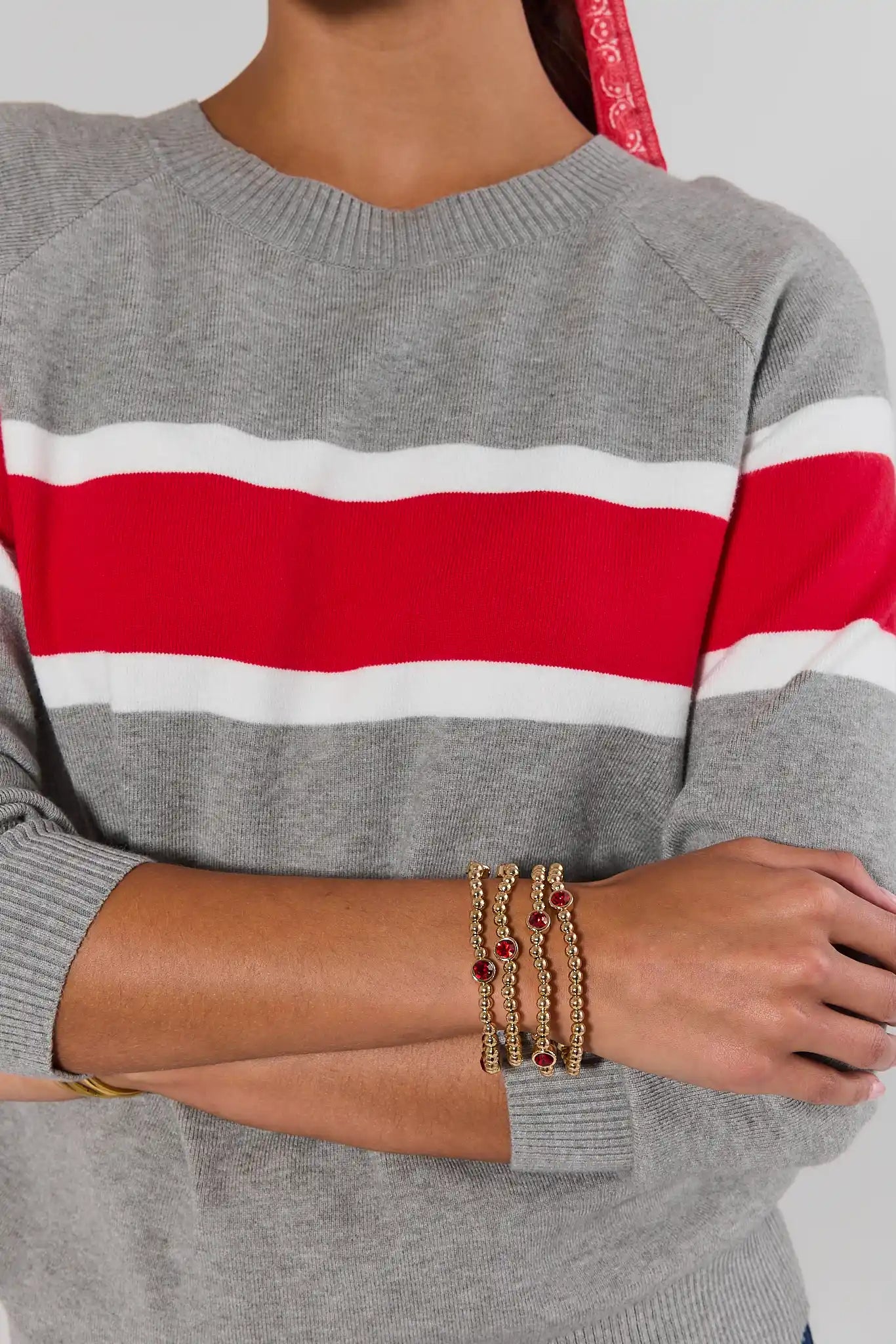Gold Beaded Red Rhinestone Bracelet on model wearing red sweater