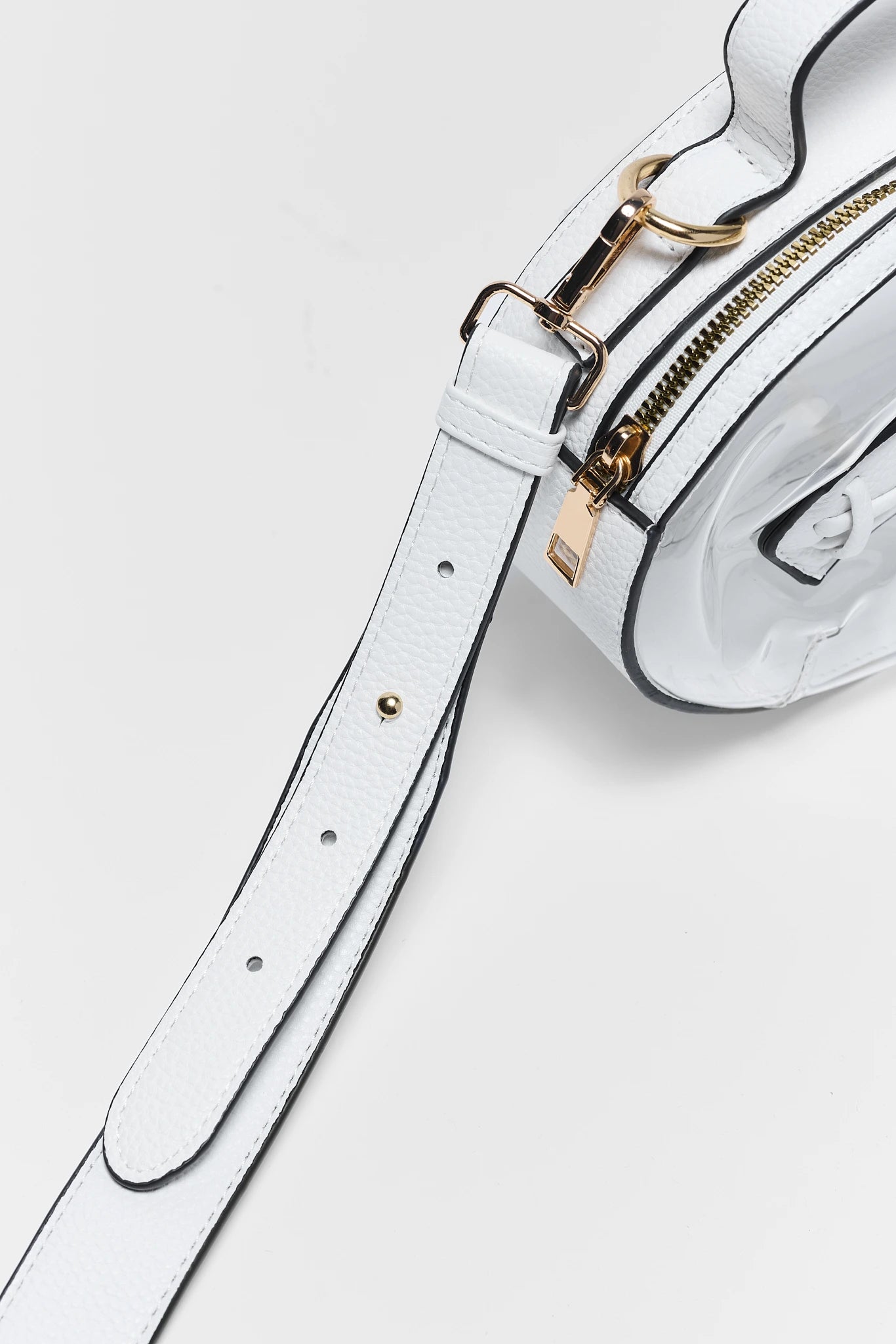 White leather shoulder bag with gold-tone hardware and black contrast stitching, shown in a close-up studio shot on a light gray background.