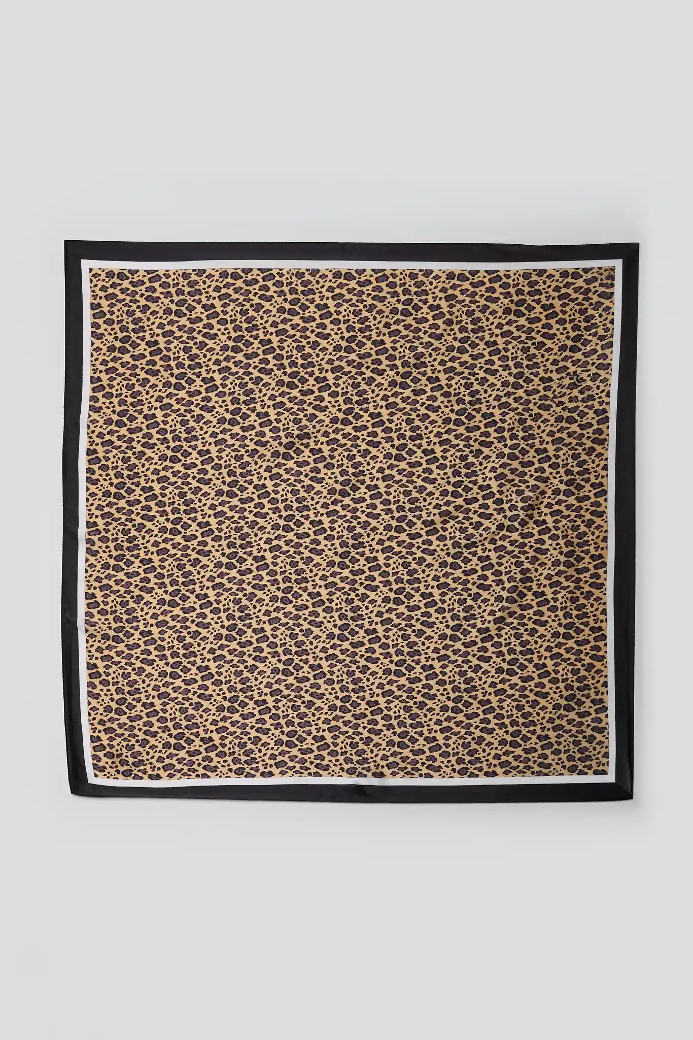 A square scarf with a classic leopard print pattern in brown and black on a beige background, finished with a solid black border and a thin white inner trim, shown flat against a light gray background.