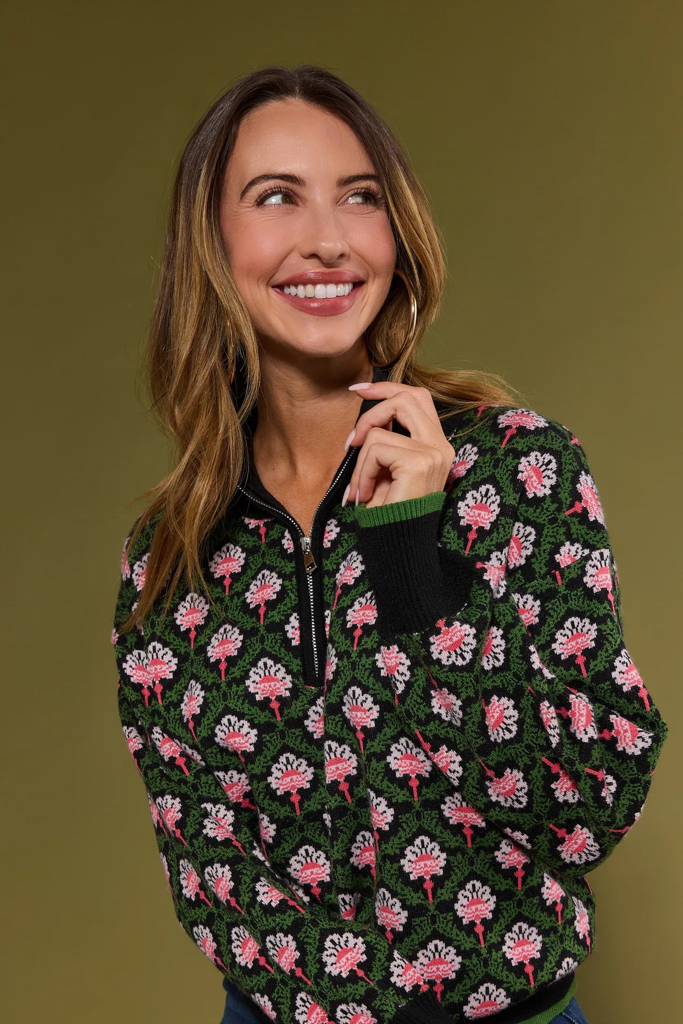 Woman wearing a patterned Janie Sweater against a green background
