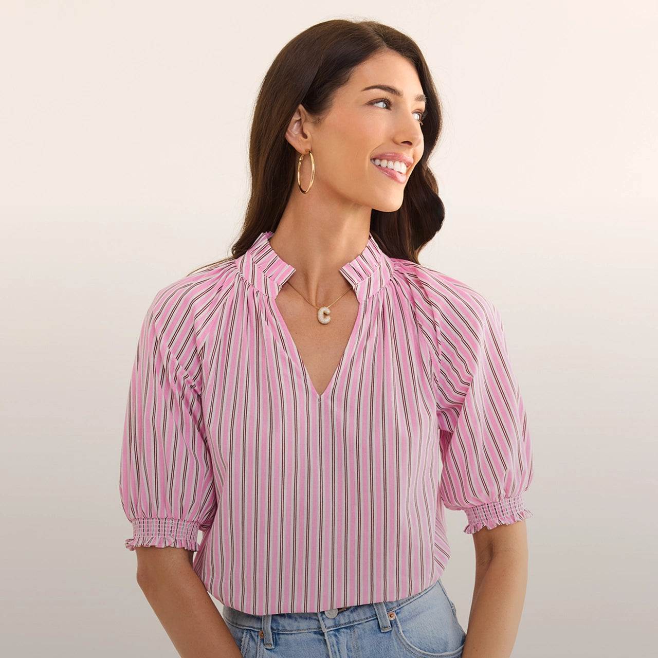 Woman wearing a pink and white striped blouse against a plain background desktop