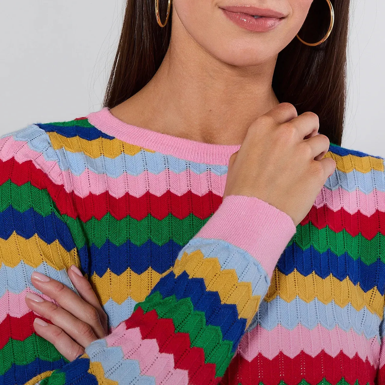 Person wearing a colorful striped sweater with a white background