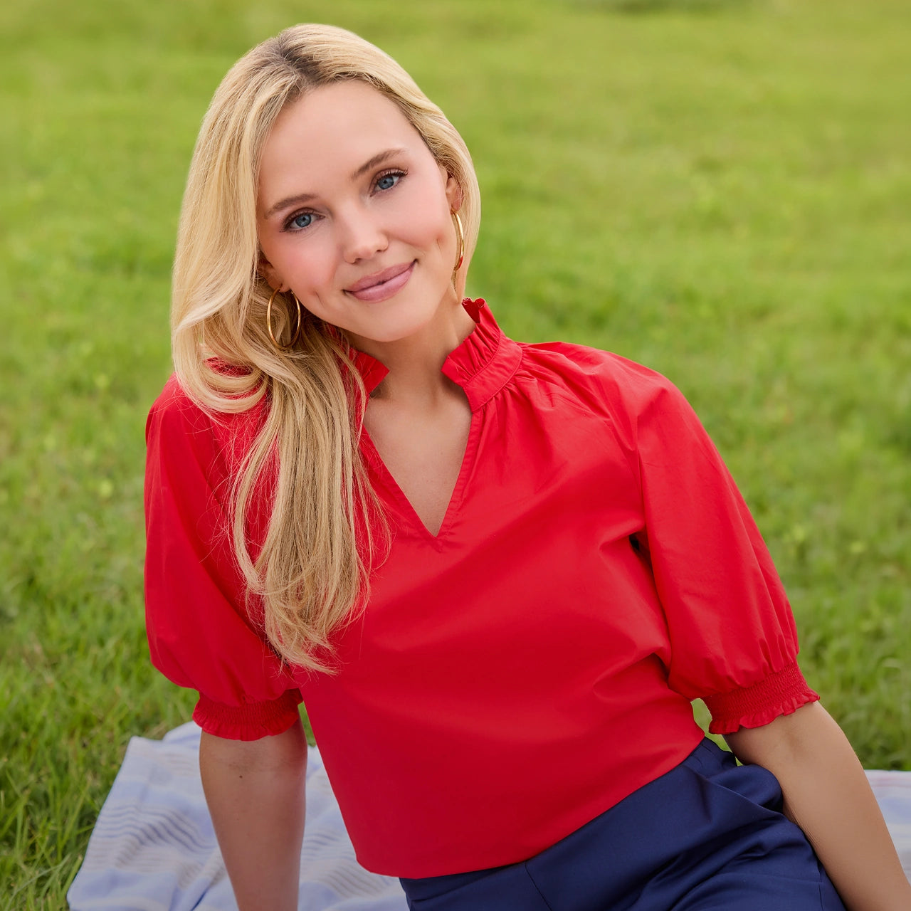 Woman in a red blouse sitting on grass desktop