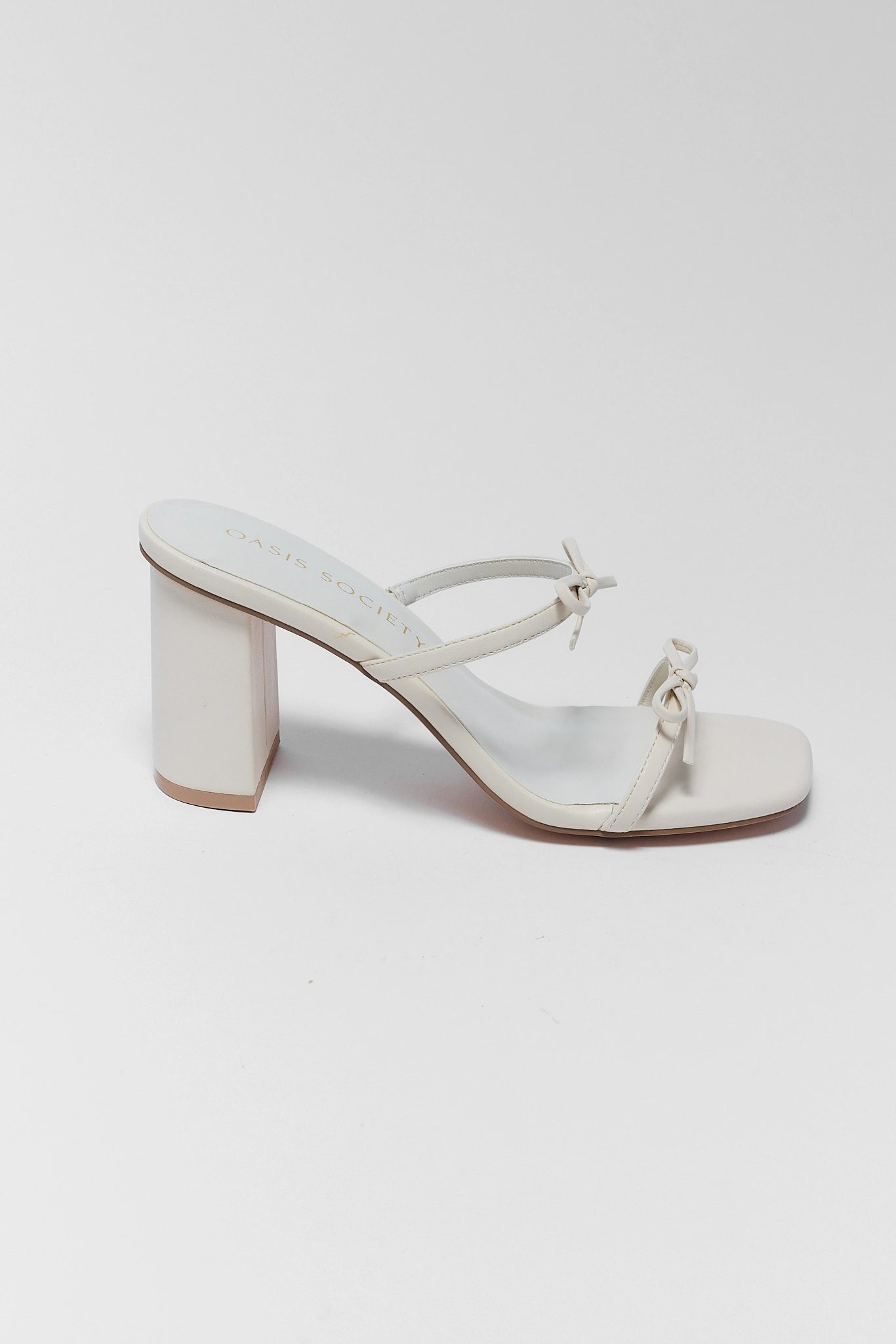 White sandal with block heel on a light gray background