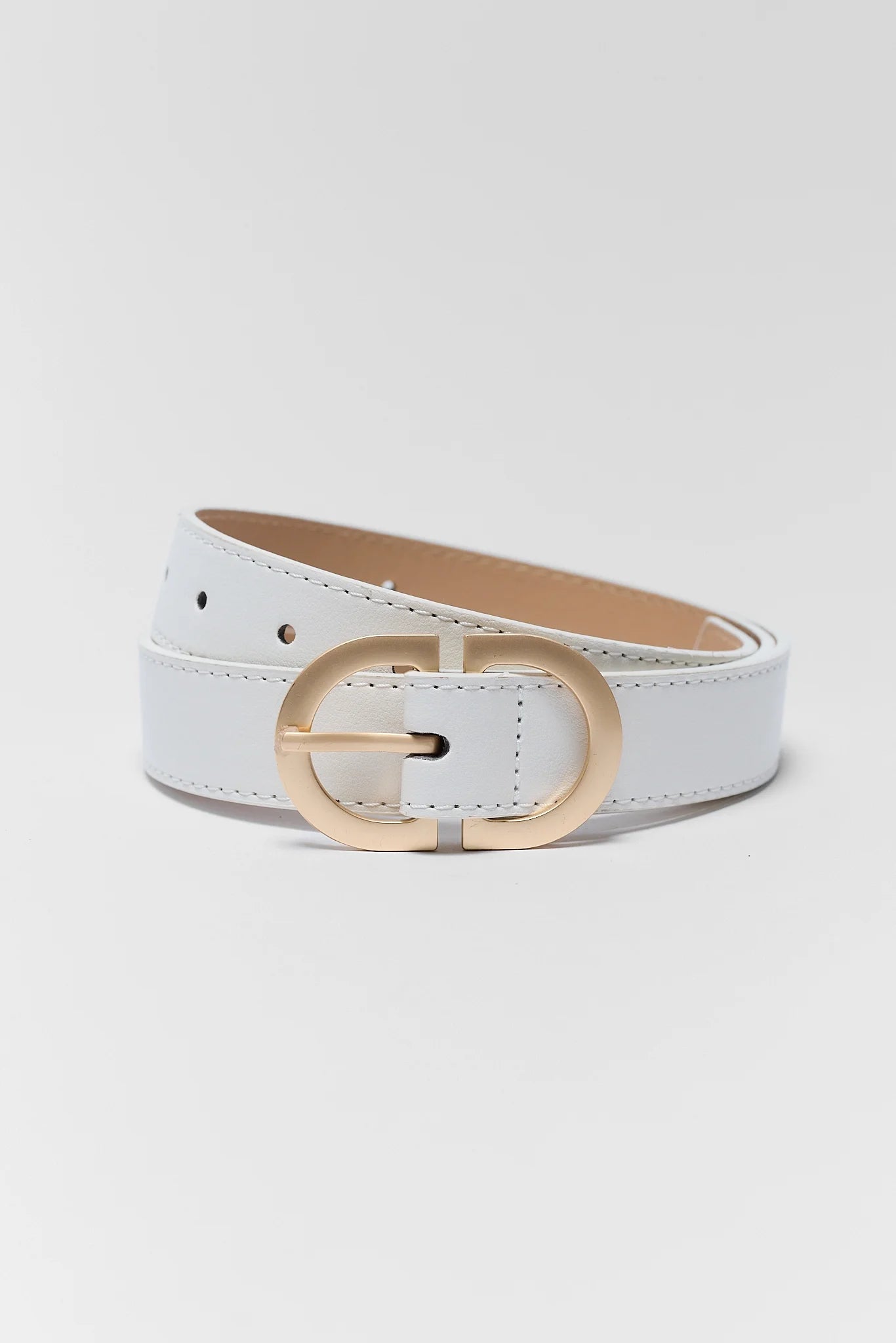 A white faux leather belt with a gold-tone oval buckle, coiled on a light gray background.