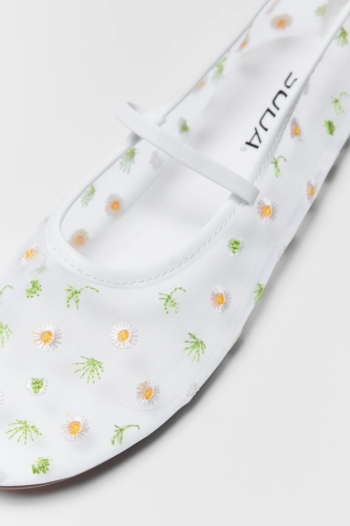 White sandal with floral pattern on a white background