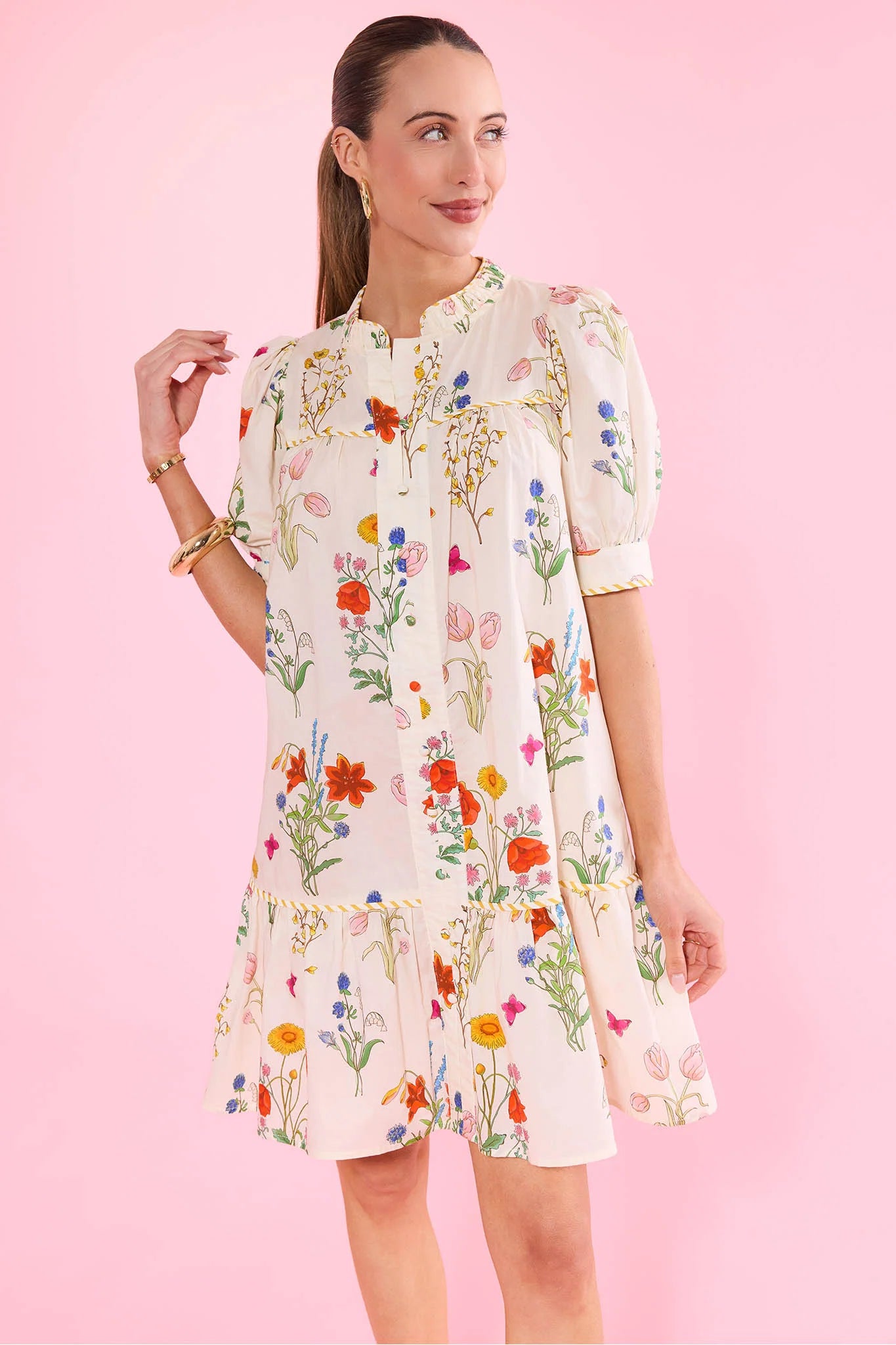 Woman wearing a floral dress against a pink background