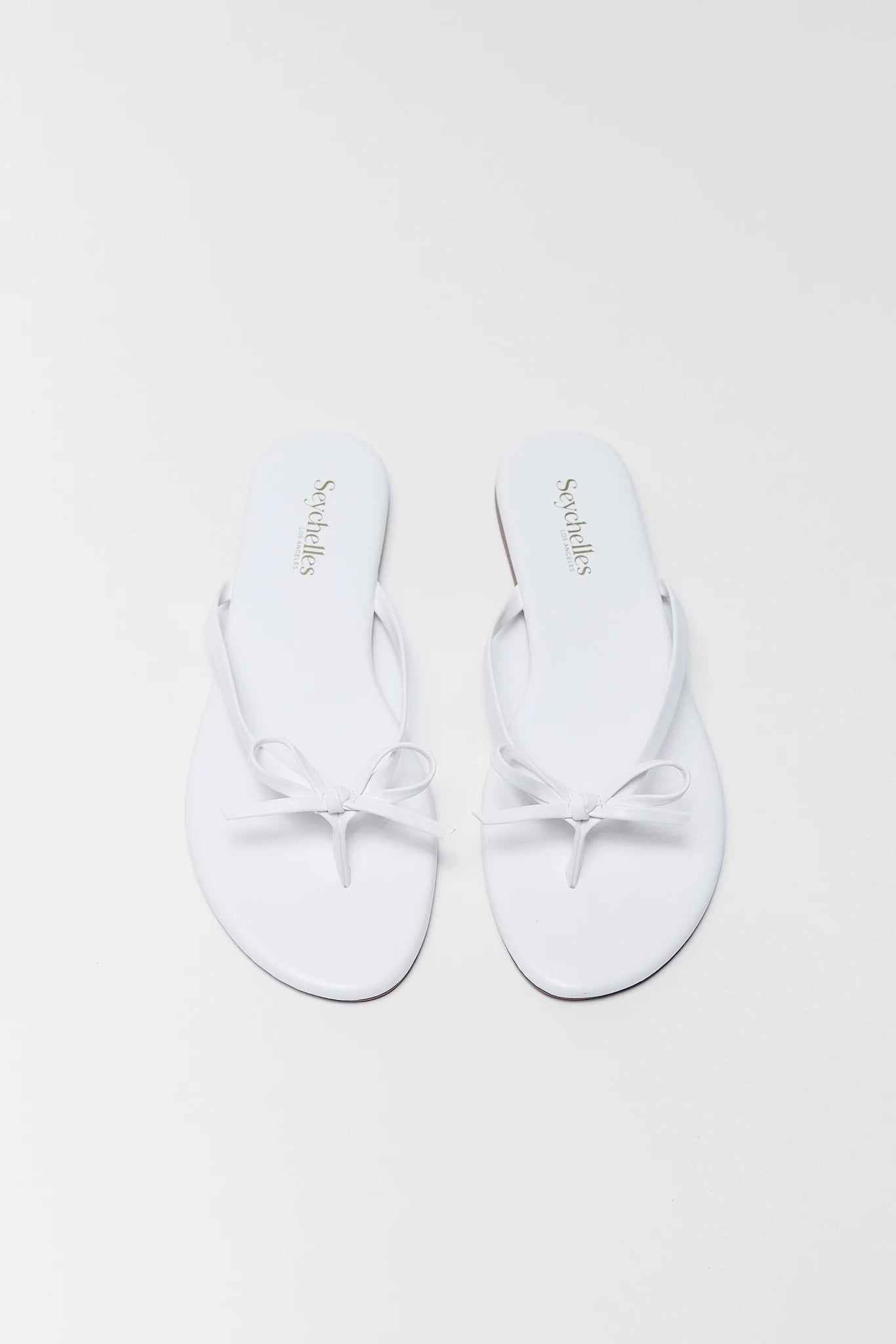 White ballet shoes with branding on a white background two