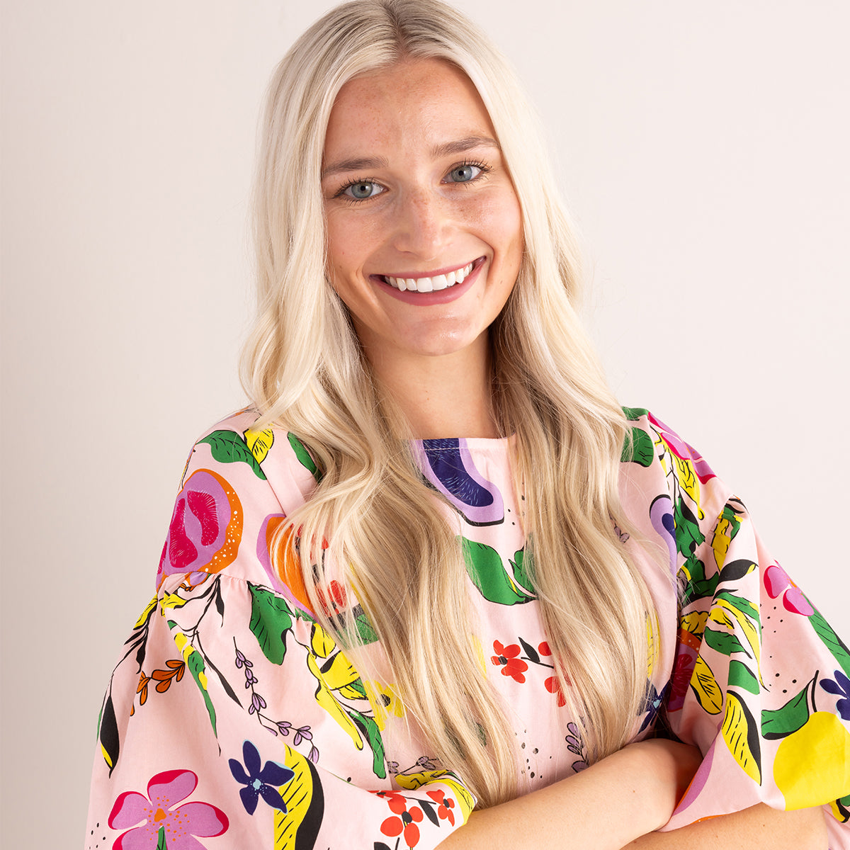 women wearing floral top with neutral background
