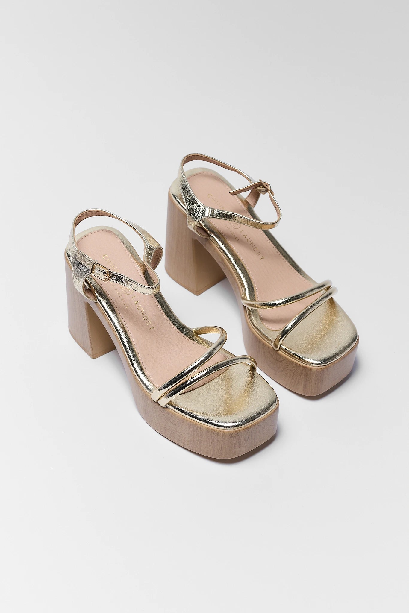 Gold platform sandals on a white background