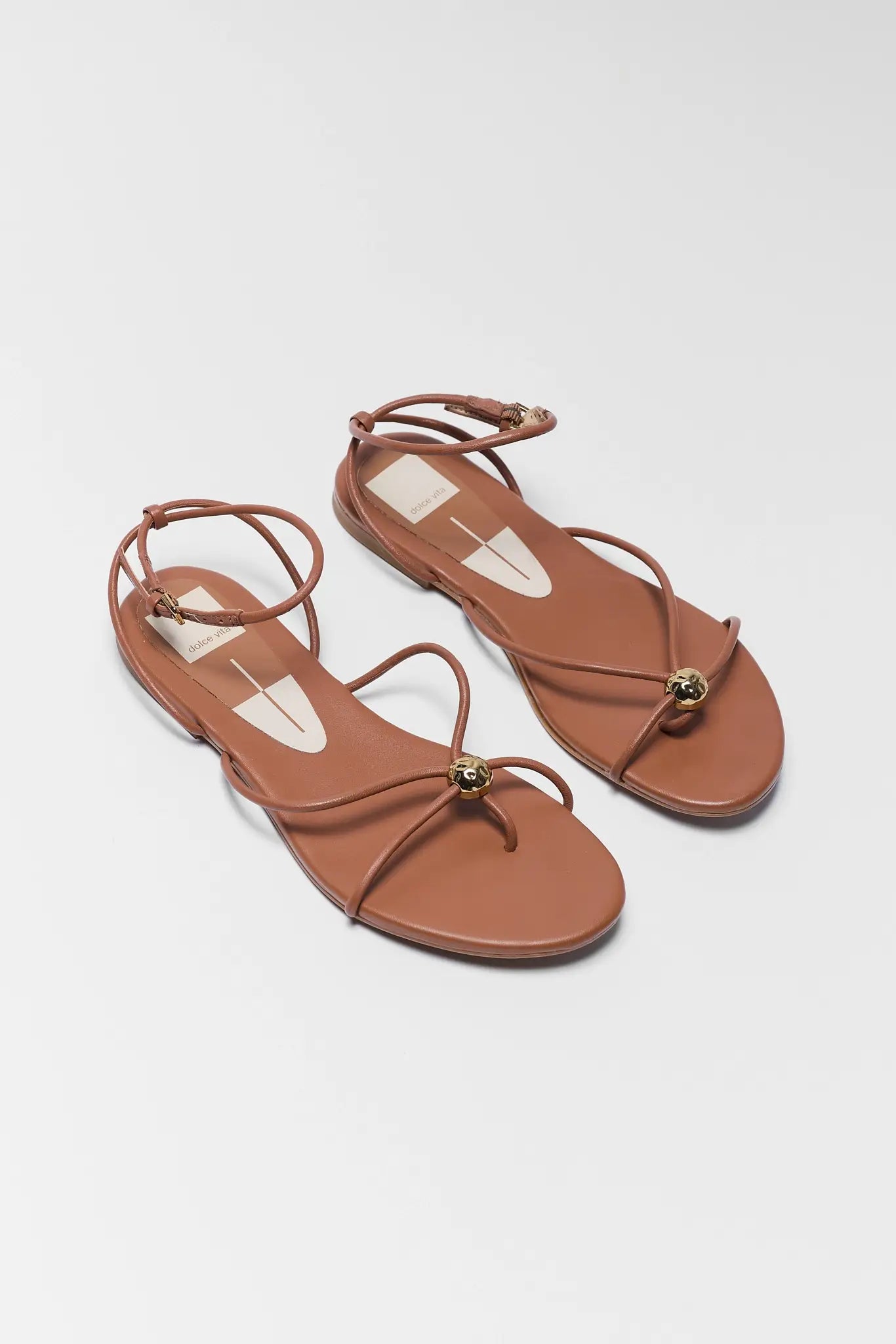 Pair of brown sandals on a light gray background