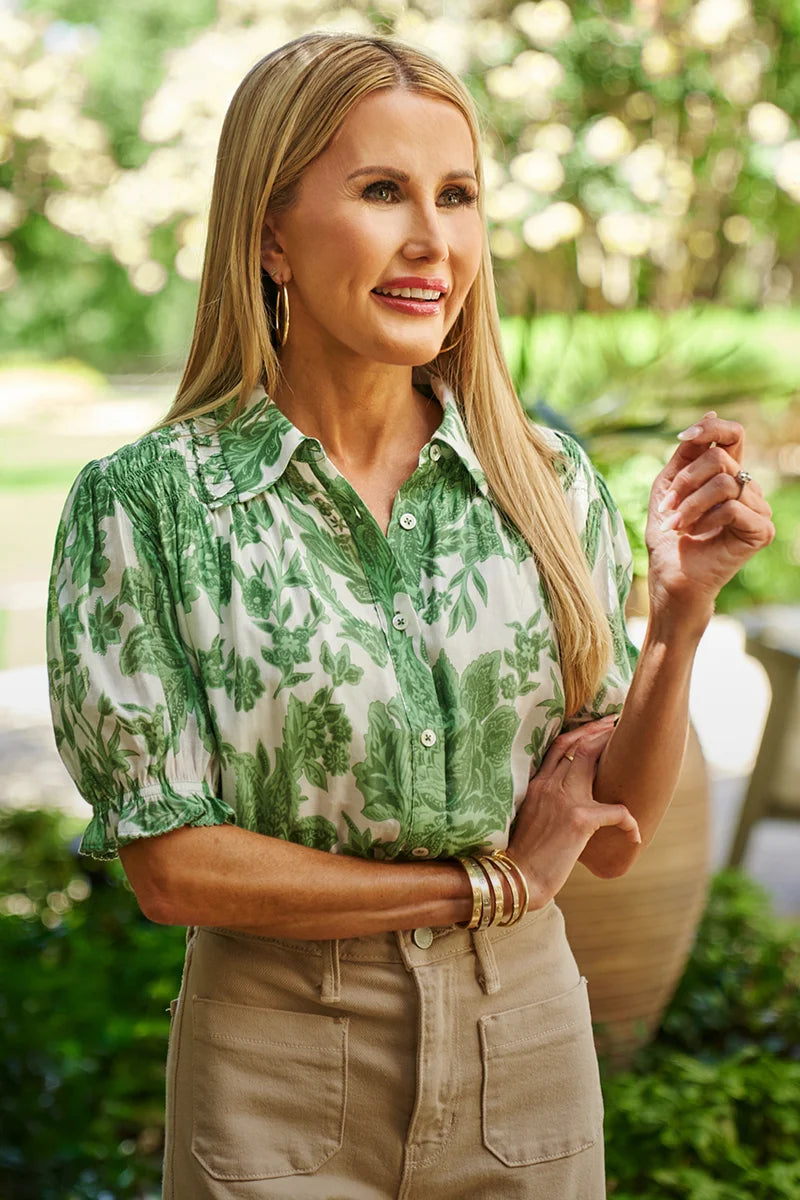 Woman wearing a green floral Mindi Top and beige pants outdoors