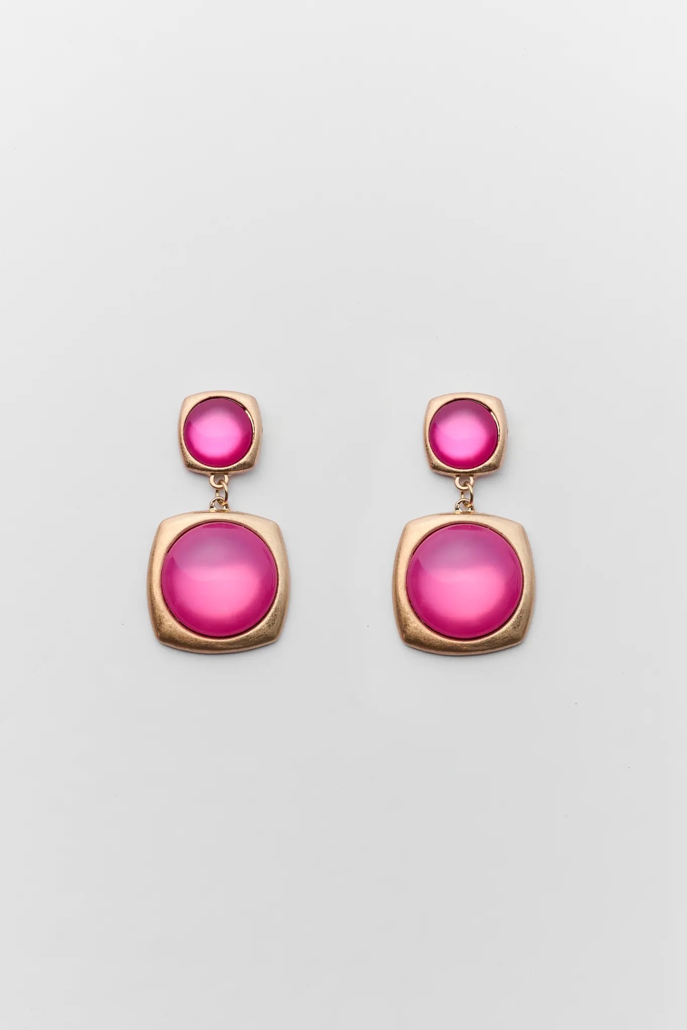 Pair of earrings with pink gemstones on a light gray background
