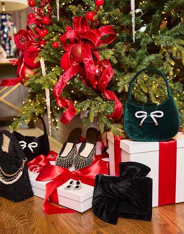 Heels, puses and earrings under a Christmas tree with presents