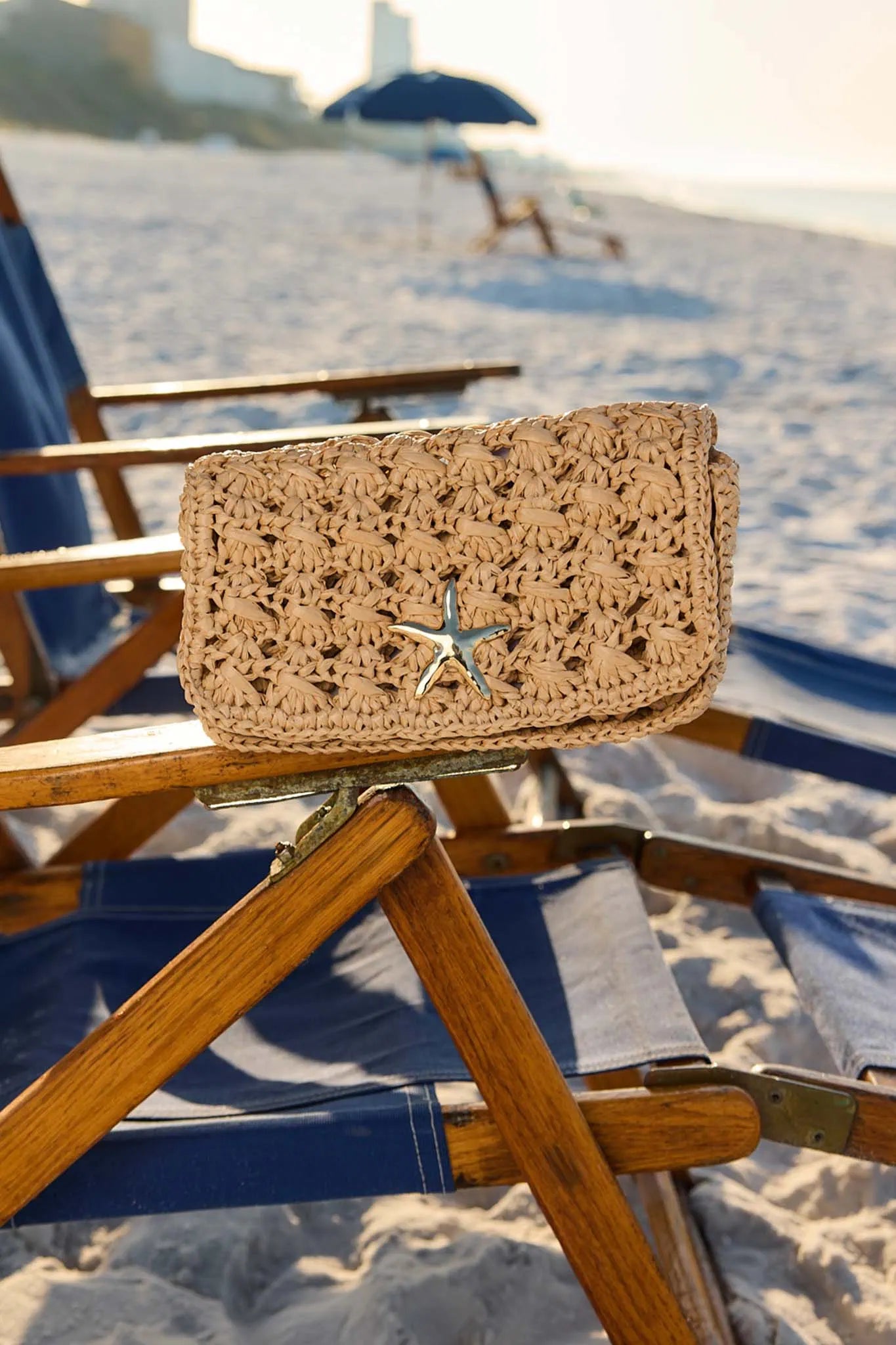 Woven clutch bag with star design on a beach chair at the beach